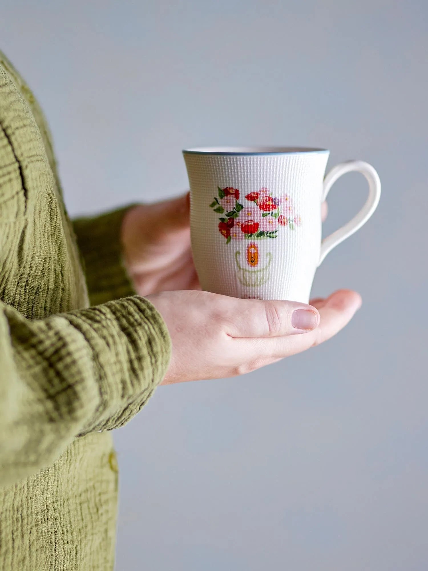 Eleganter Becher aus Steingut mit floralem Design, ideal für heiße Getränke. Spülmaschinen- und mikrowellengeeignet.