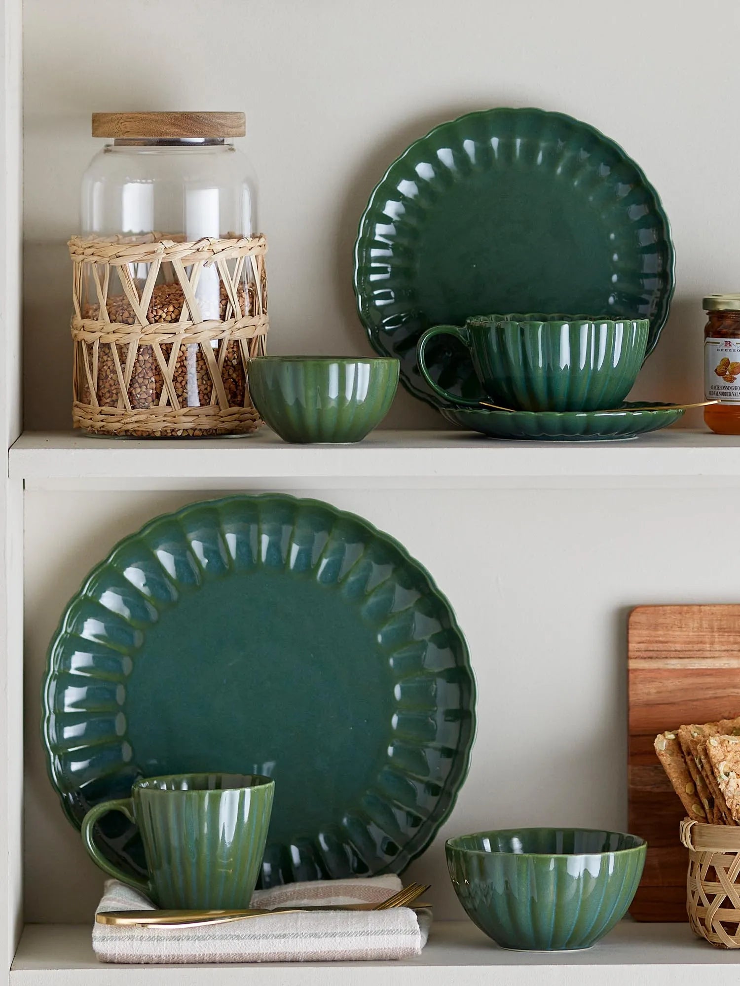 Elegante grüne Steingut-Tasse mit Untertasse, gewelltem Rand und langlebiger Glasur, ideal für stilvolle Kaffeepausen.