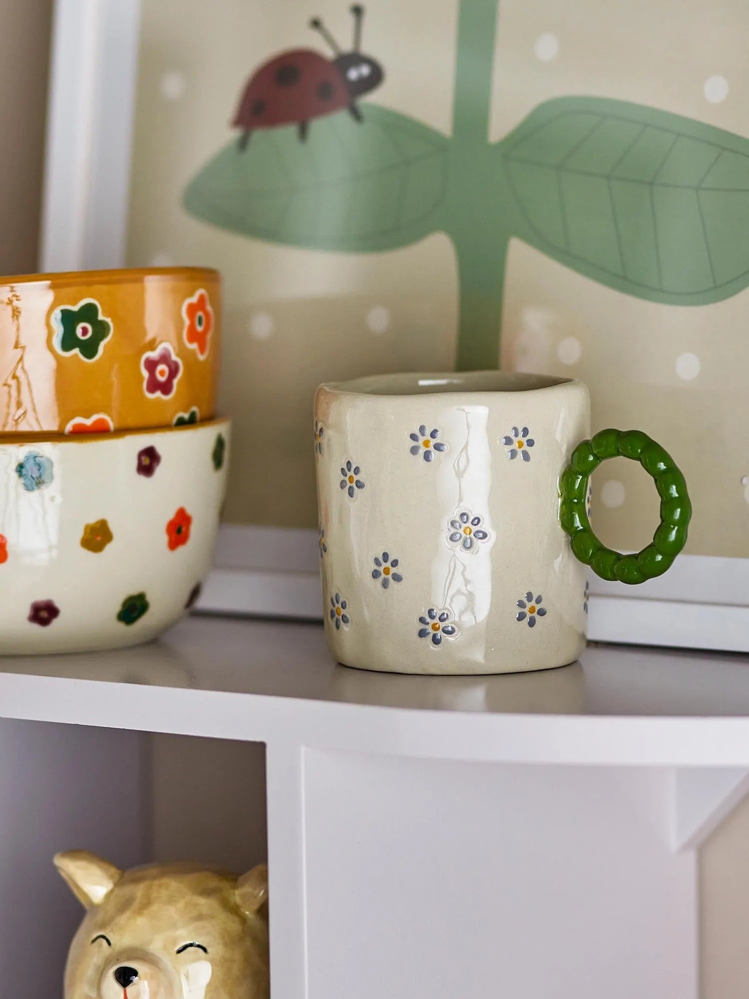 Die Dorthea Tasse: charmantes Steingut mit handbemaltem Blumenmuster, ideal für Tee oder Kaffee, bringt skandinavische Gemütlichkeit.