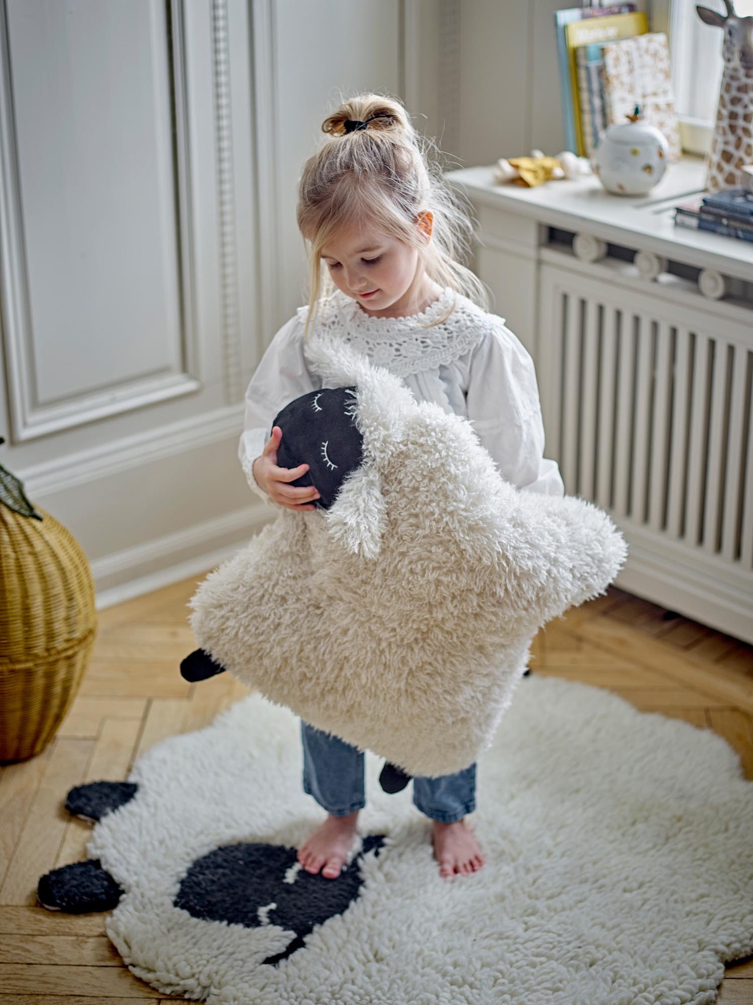 Der weiße Dolly Teppich von Bloomingville Mini aus Wolle ist kuschelig, elegant und perfekt für das Kinderzimmer.