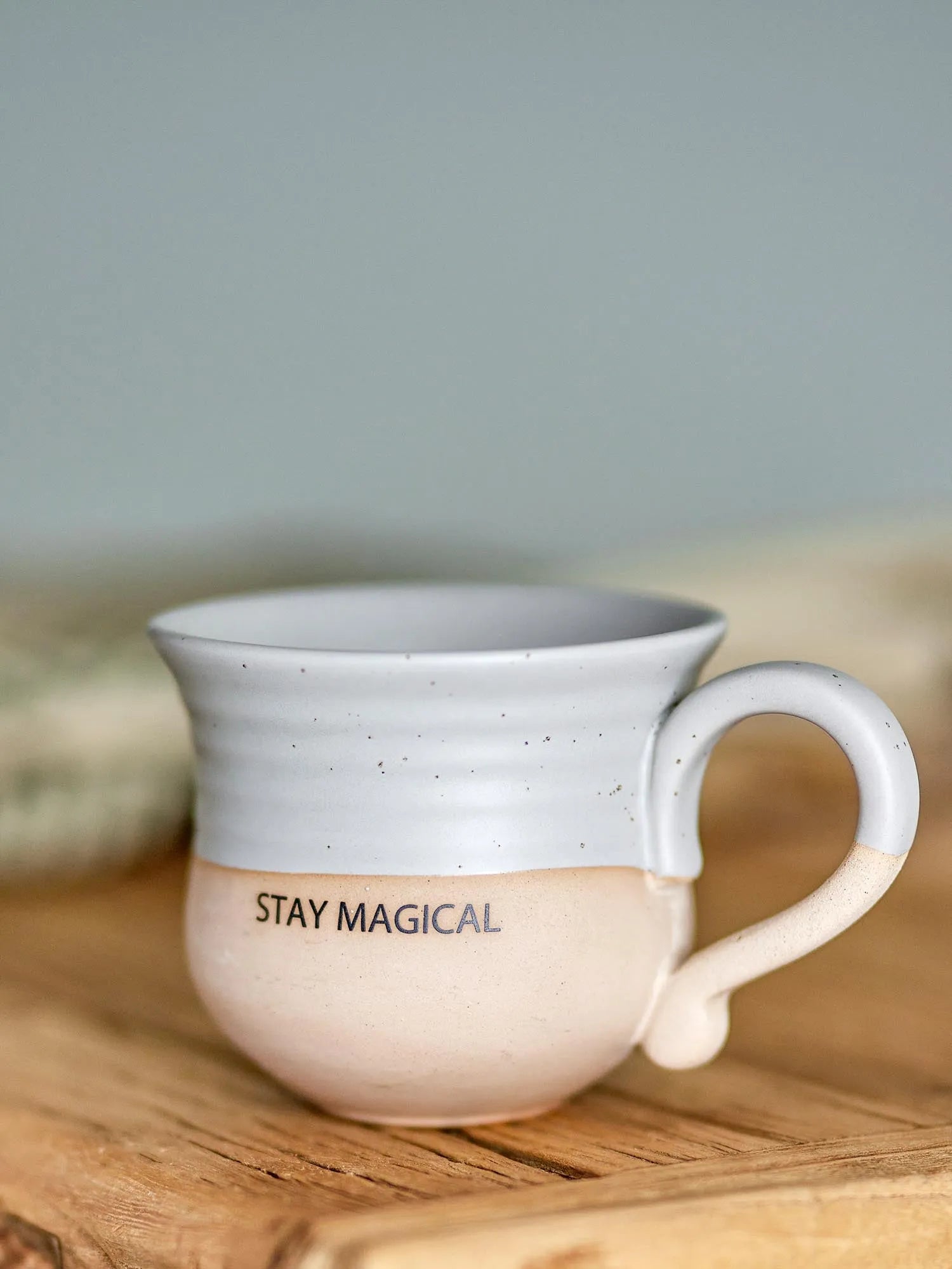Die Claire Tasse in Grau aus Steingut vereint Stil und Funktionalität mit "Stay magical"-Motiv, ideal für jeden Anlass.