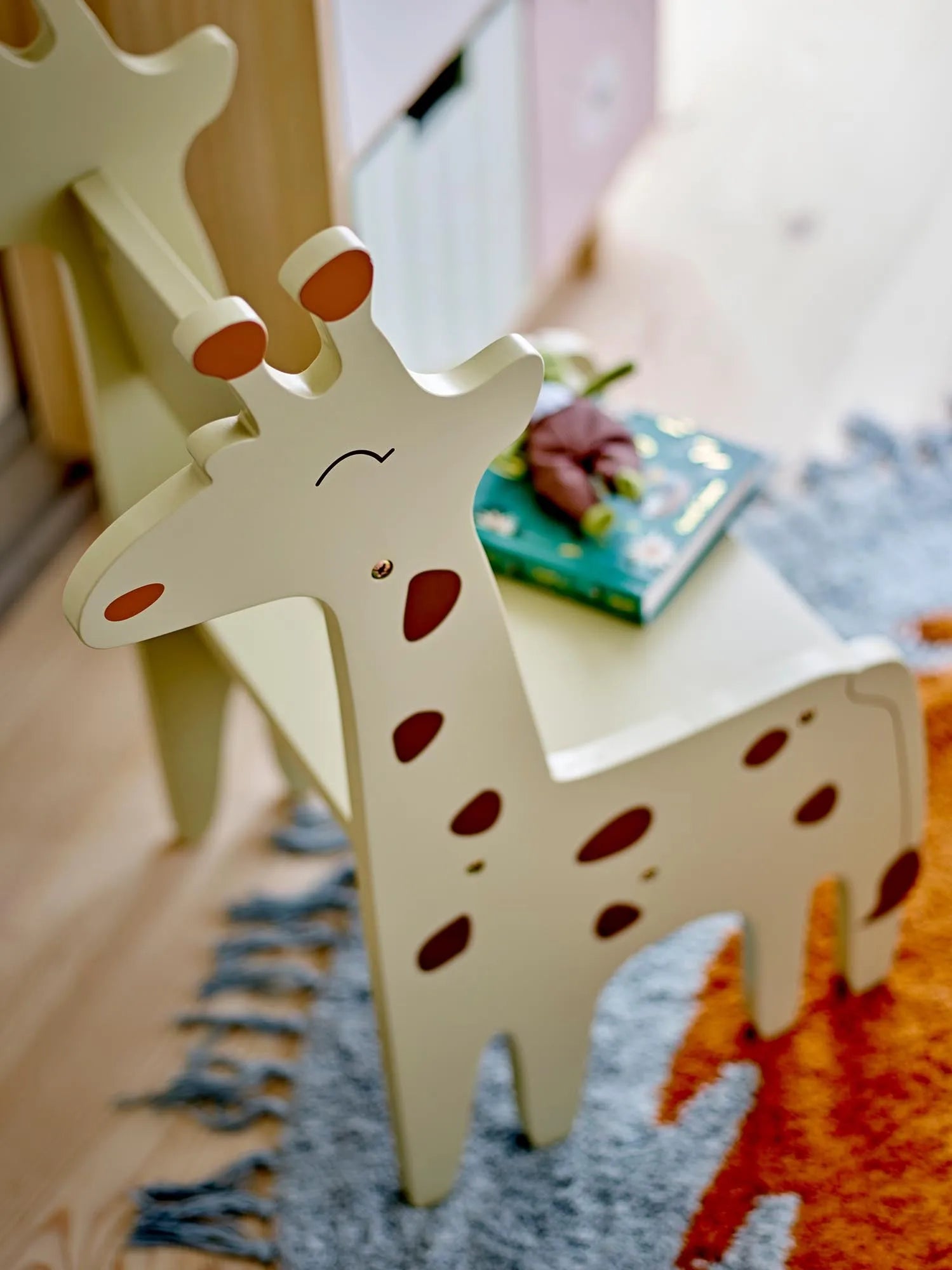 Der Ibber Stuhl in Giraffenform, aus grauem, FSC®100% MDF, vereint verspieltes Design mit nachhaltiger Qualität.