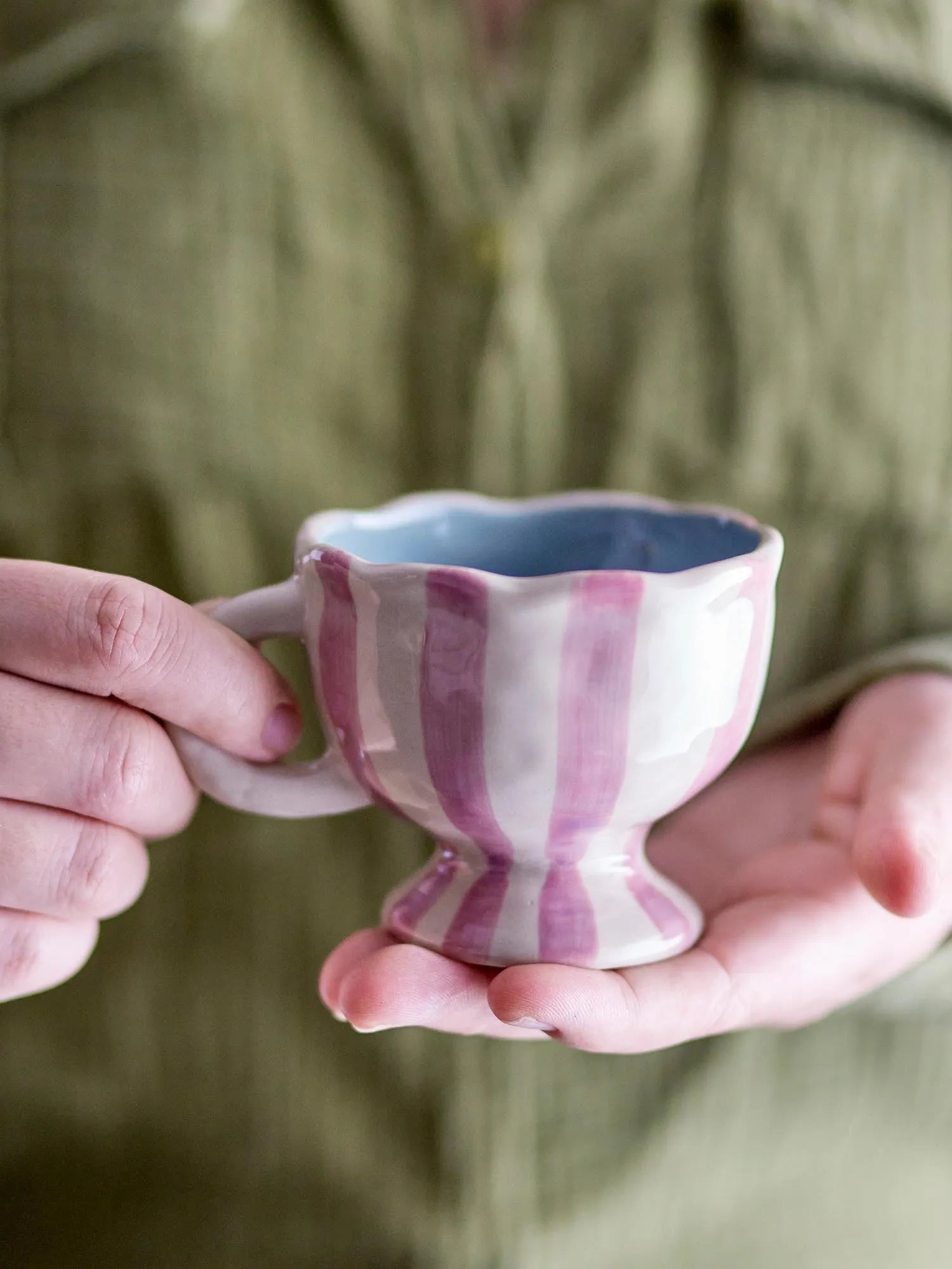 Die Willa Tasse in zartem Rosa, aus robustem Steingut, vereint Eleganz und Funktionalität mit handbemalten Streifen.