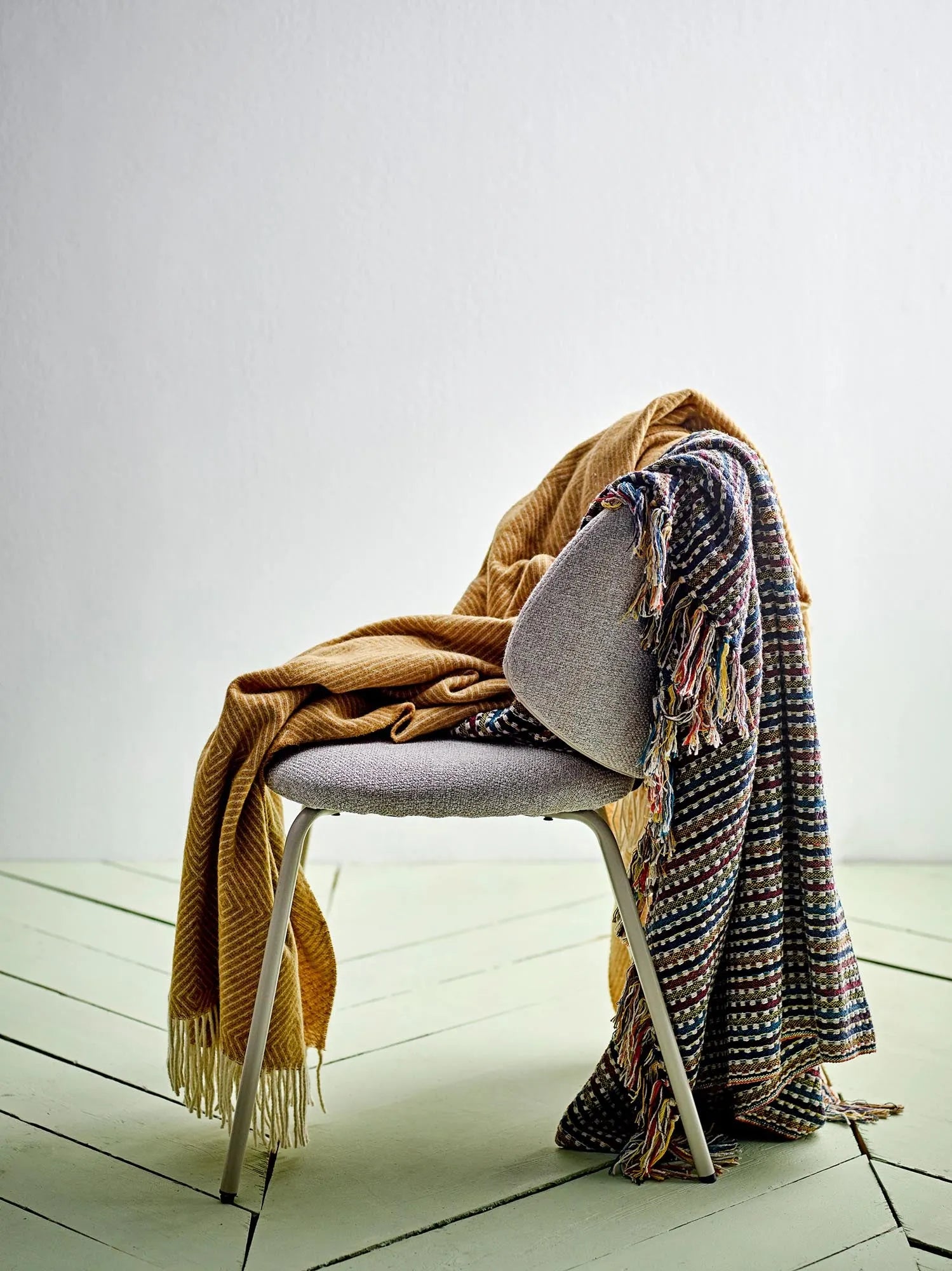 Eleganter Esszimmerstuhl mit grauem Polyester-Bouclé-Bezug, stabilen Metallbeinen und hohem Sitzkomfort.