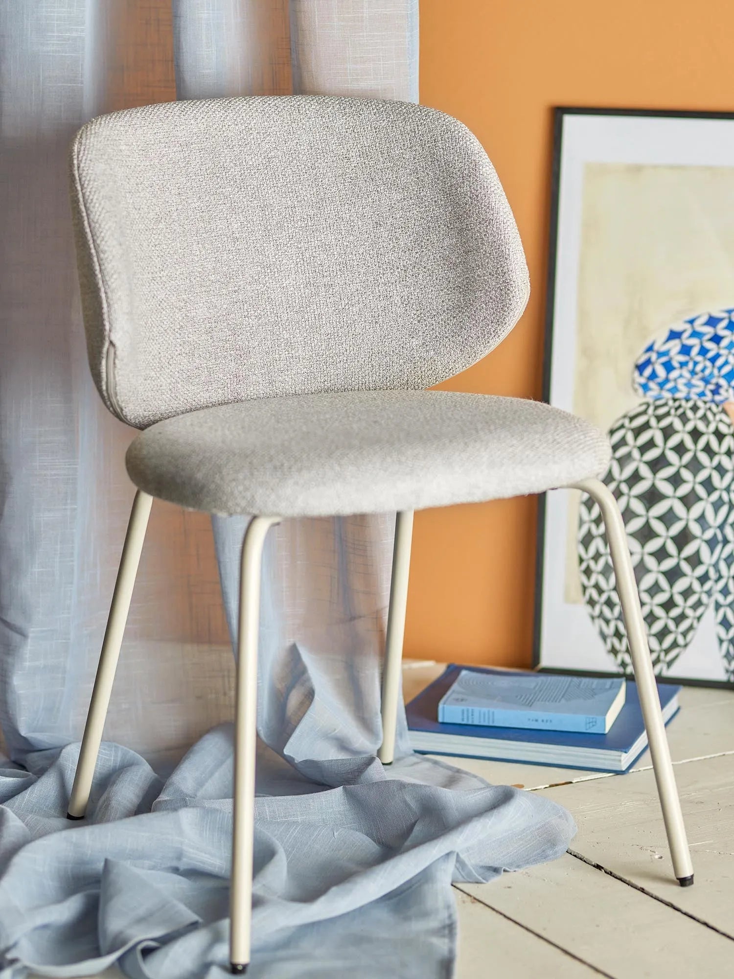 Eleganter Esszimmerstuhl mit grauem Polyester-Bouclé-Bezug, stabilen Metallbeinen und hohem Sitzkomfort.