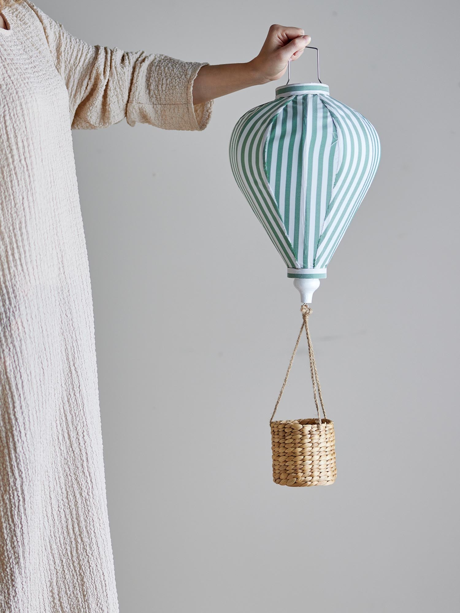 Ein zauberhaftes Heissluftballon-Mobile in sanftem Grün, das Kinderträume beflügelt und sanft im Raum schwebt.