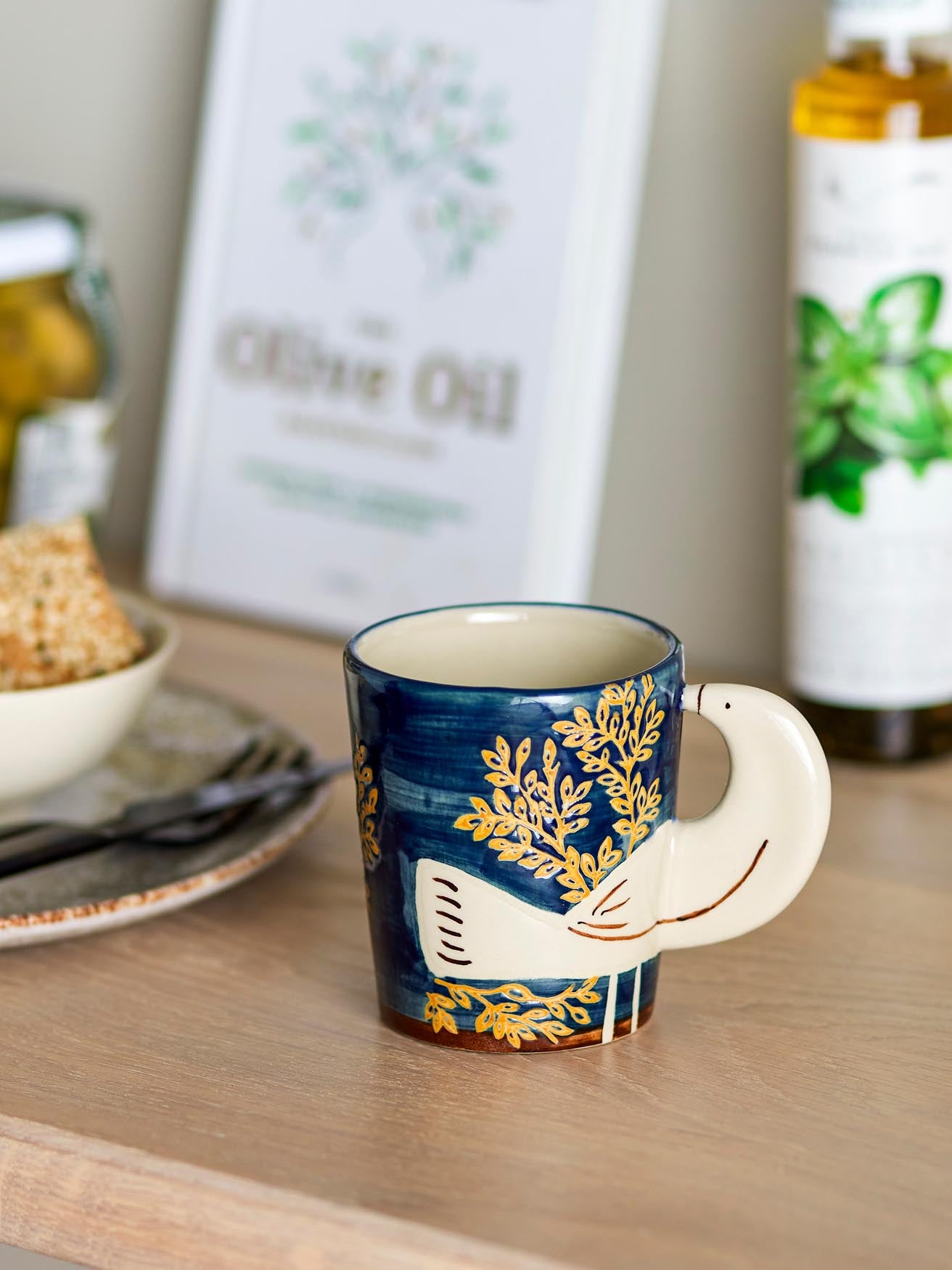 Genießen Sie stilvolle Momente mit der Hezha Tasse von Bloomingville – ein handgefertigtes Steingut-Unikat mit einzigartigem Vogelmotiv.