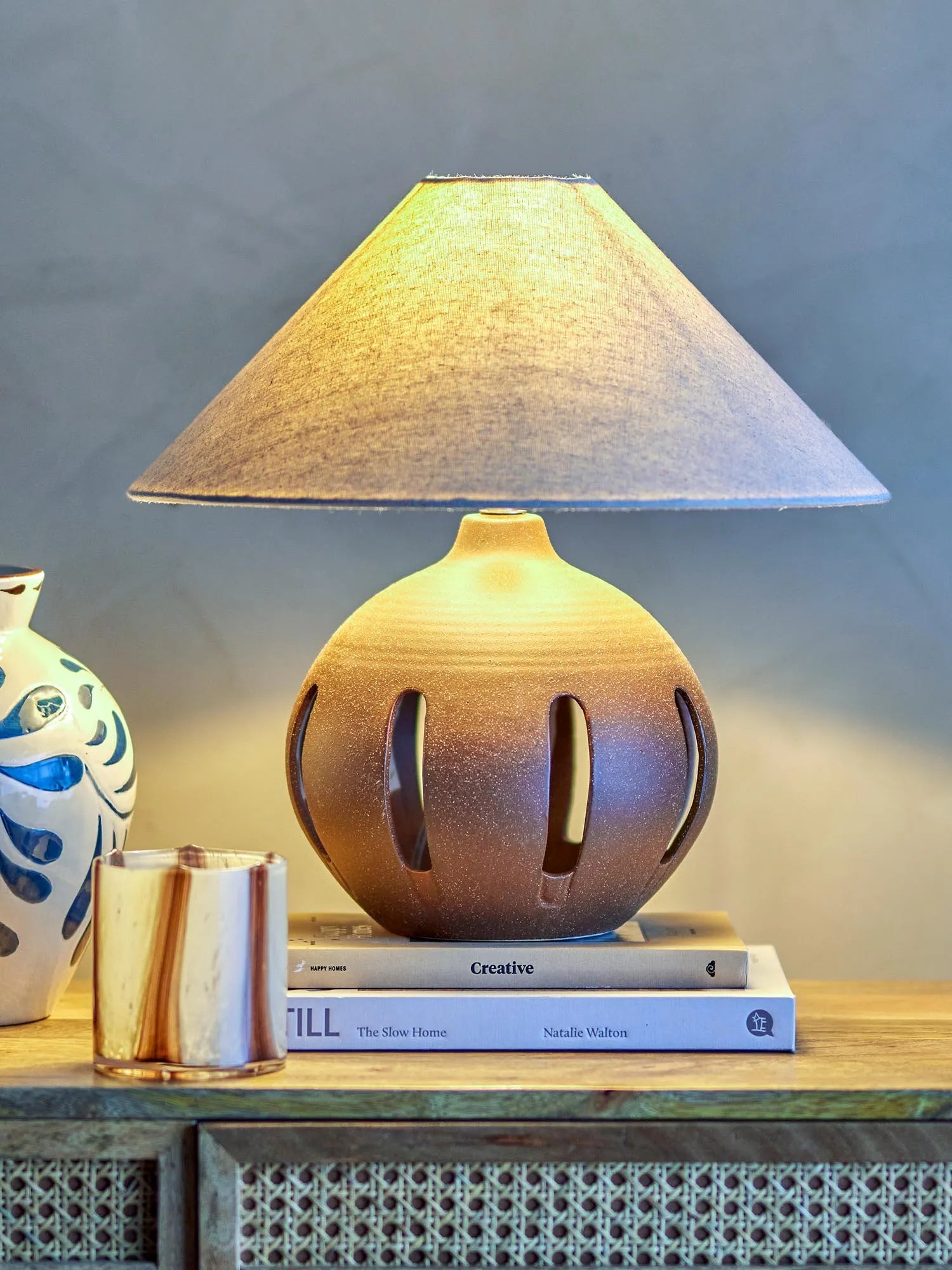 Die Liana Tischlampe von Bloomingville vereint robustes Steingut in Braun mit einem eleganten Leinenschirm für stilvolle Beleuchtung.