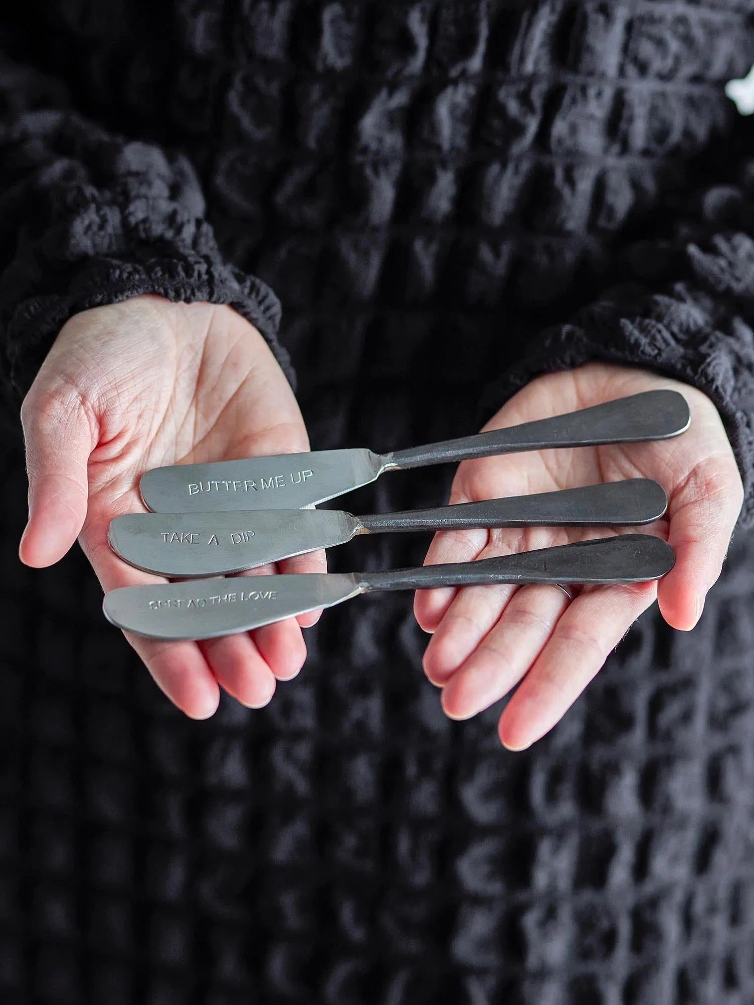 Elegantes Buttermesser-Set aus Edelstahl, ideal zum Streichen und Dekorieren, mit charmanten Zitaten für stilvolle Tischmomente.