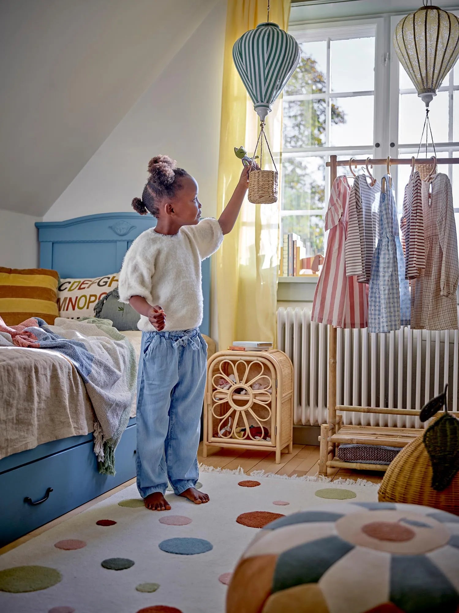 Ein zauberhaftes, gelbes Heißluftballon-Mobile mit Blumenmuster und Lichterkette, ideal für das Kinderzimmer.