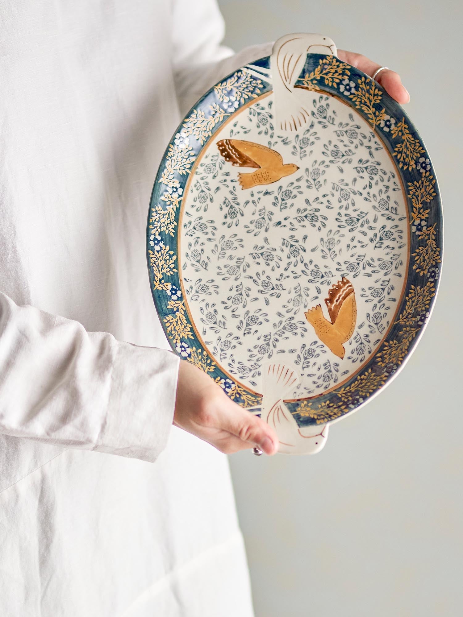 Elegantes Steingut-Tablett in Blau mit handdekoriertem Vogelmuster, ideal für stilvolles Servieren und Dekorieren.