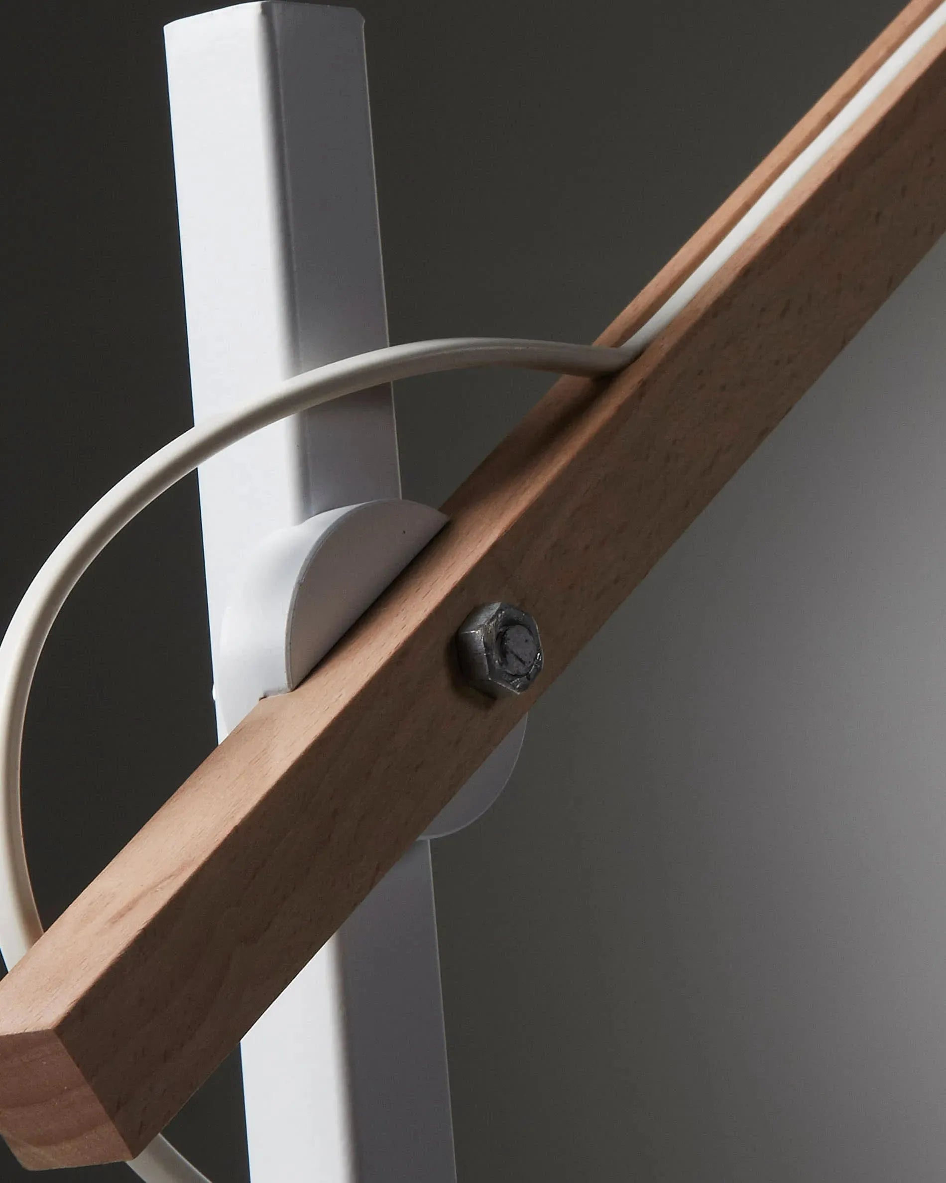 Die Kosta Tischlampe vereint Holz und Metall in einem eleganten Design, das warmes Licht durch einen Baumwollschirm spendet.