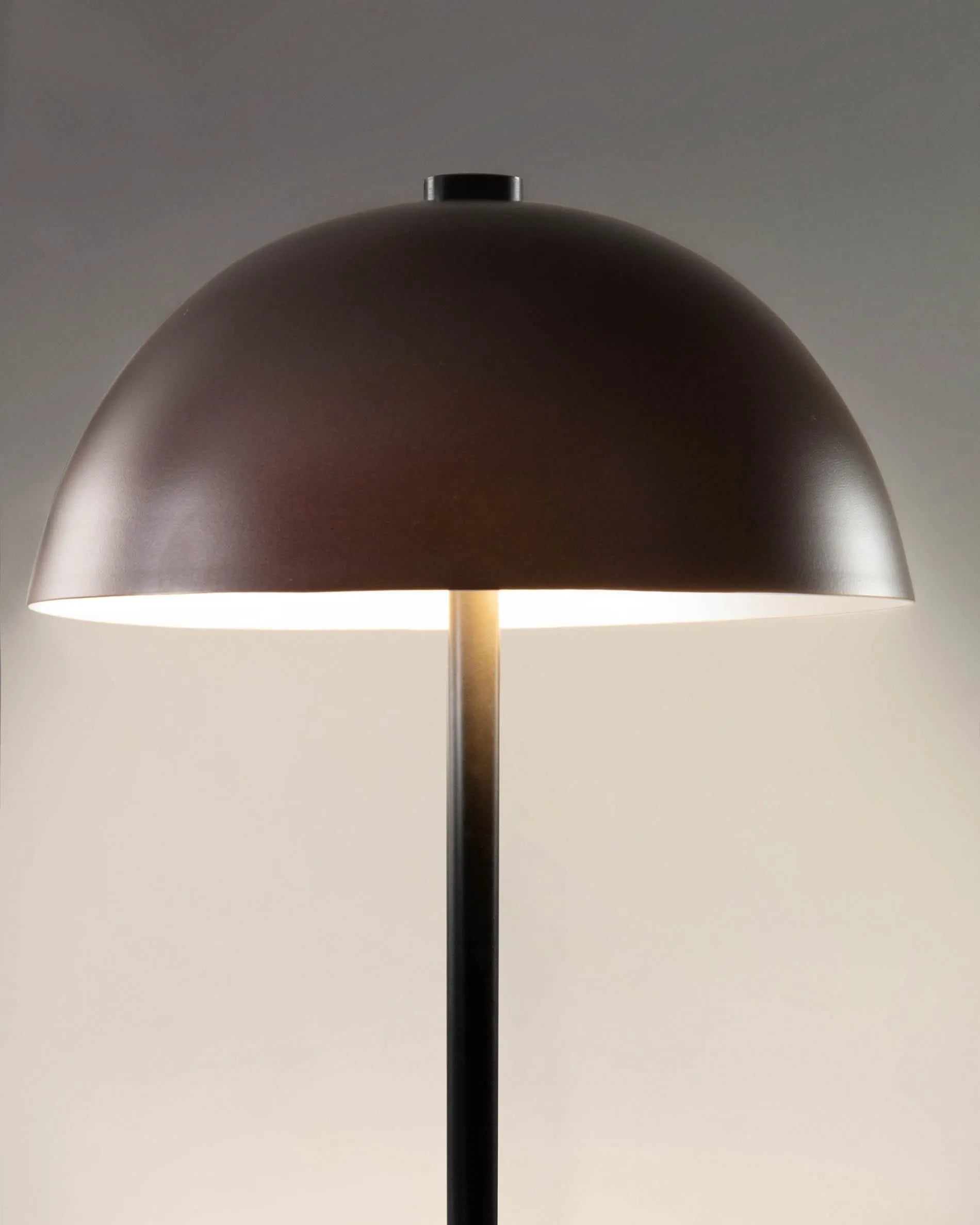 Elegante Tischlampe aus Metall in Kastanienbraun, die mit ihrem modernen Design und warmem Licht jeden Raum veredelt.