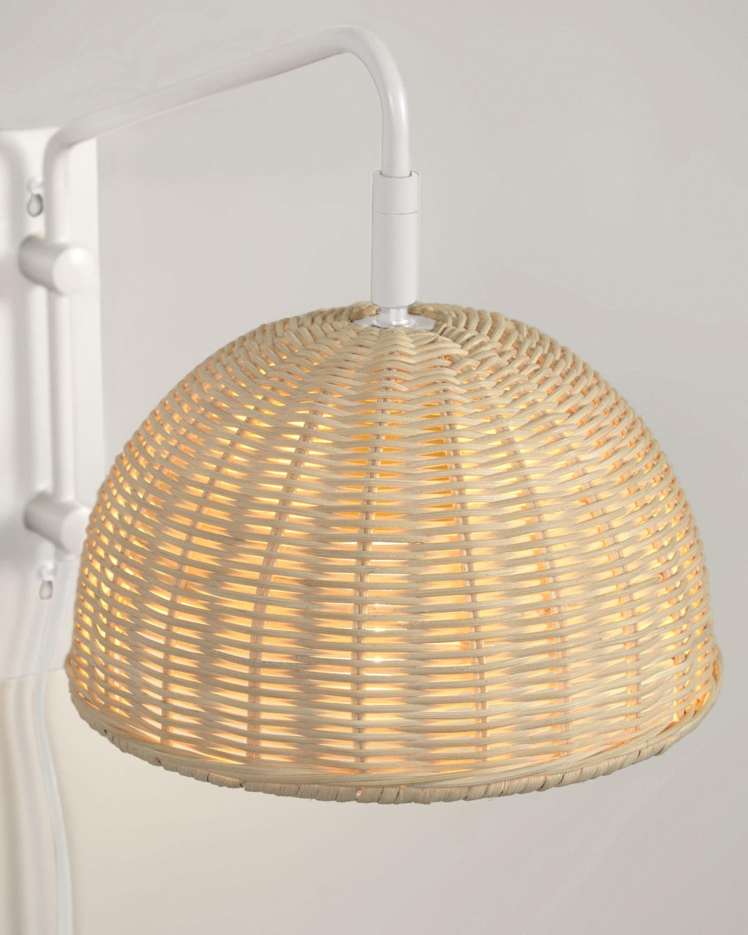 Stilvolle Wandlampe aus weißem Metall und Rattan mit natürlichem Finish, perfekt für eine warme und moderne Raumbeleuchtung.