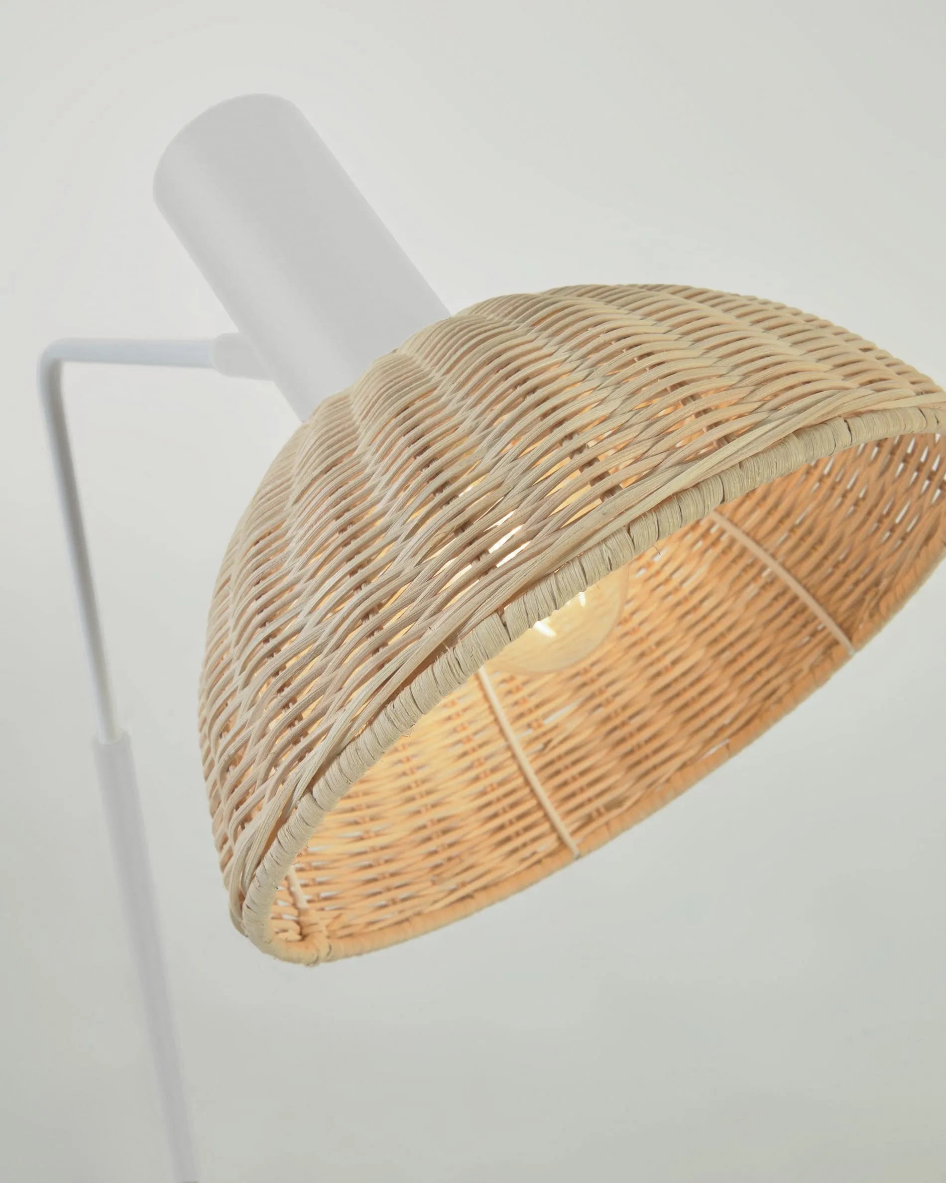 Elegante Stehlampe aus weißem Metall und handgeflochtenem Rattan, die Wärme und Stil in jeden Raum bringt.