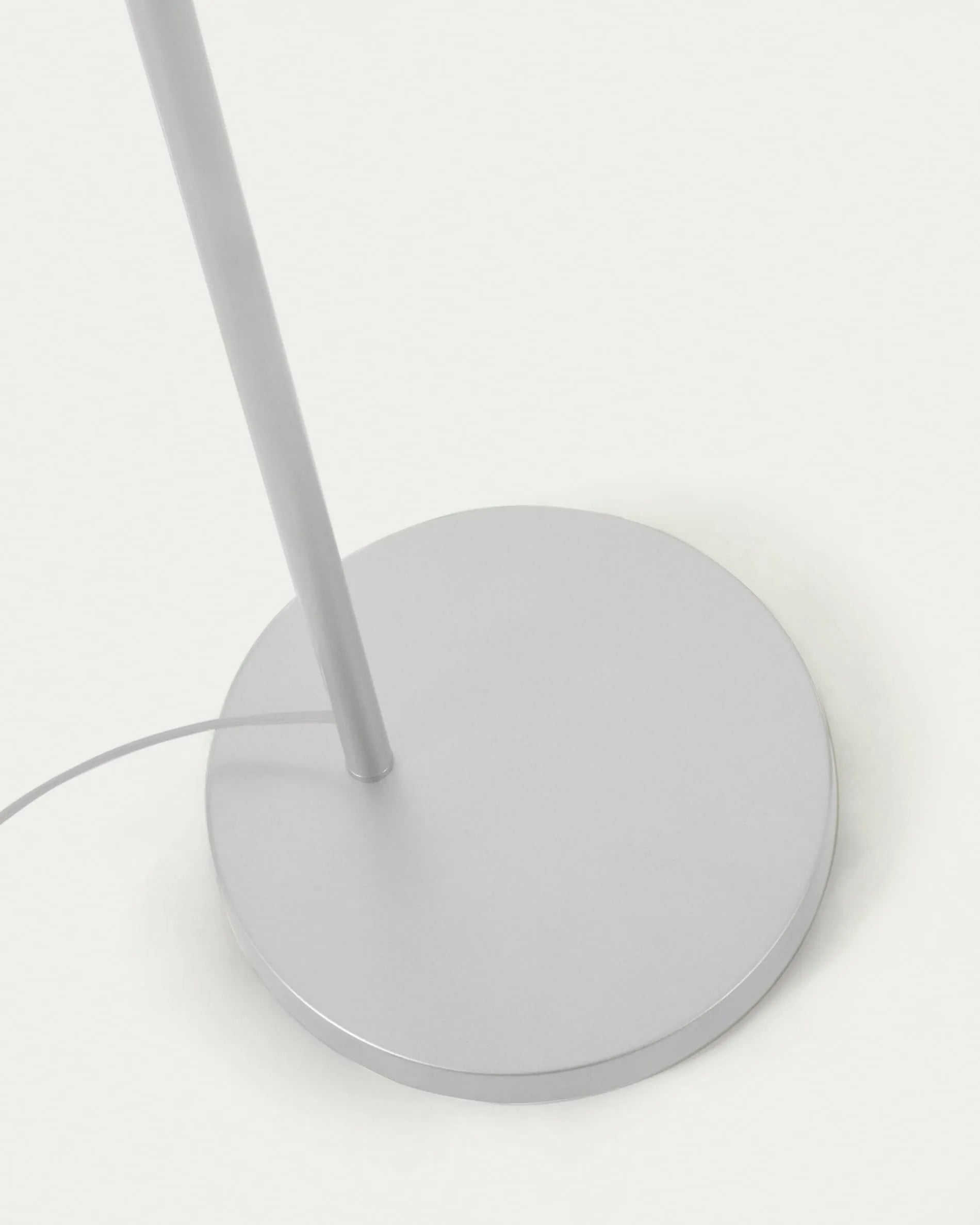 Elegante Stehlampe aus weißem Metall und handgeflochtenem Rattan, die Wärme und Stil in jeden Raum bringt.