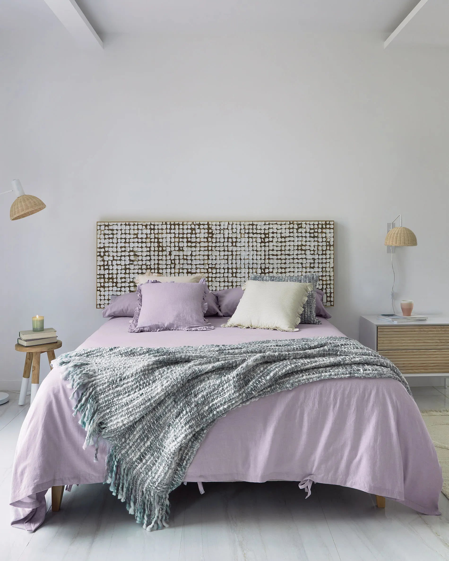 Elegante Stehlampe aus weißem Metall und handgeflochtenem Rattan, die Wärme und Stil in jeden Raum bringt.