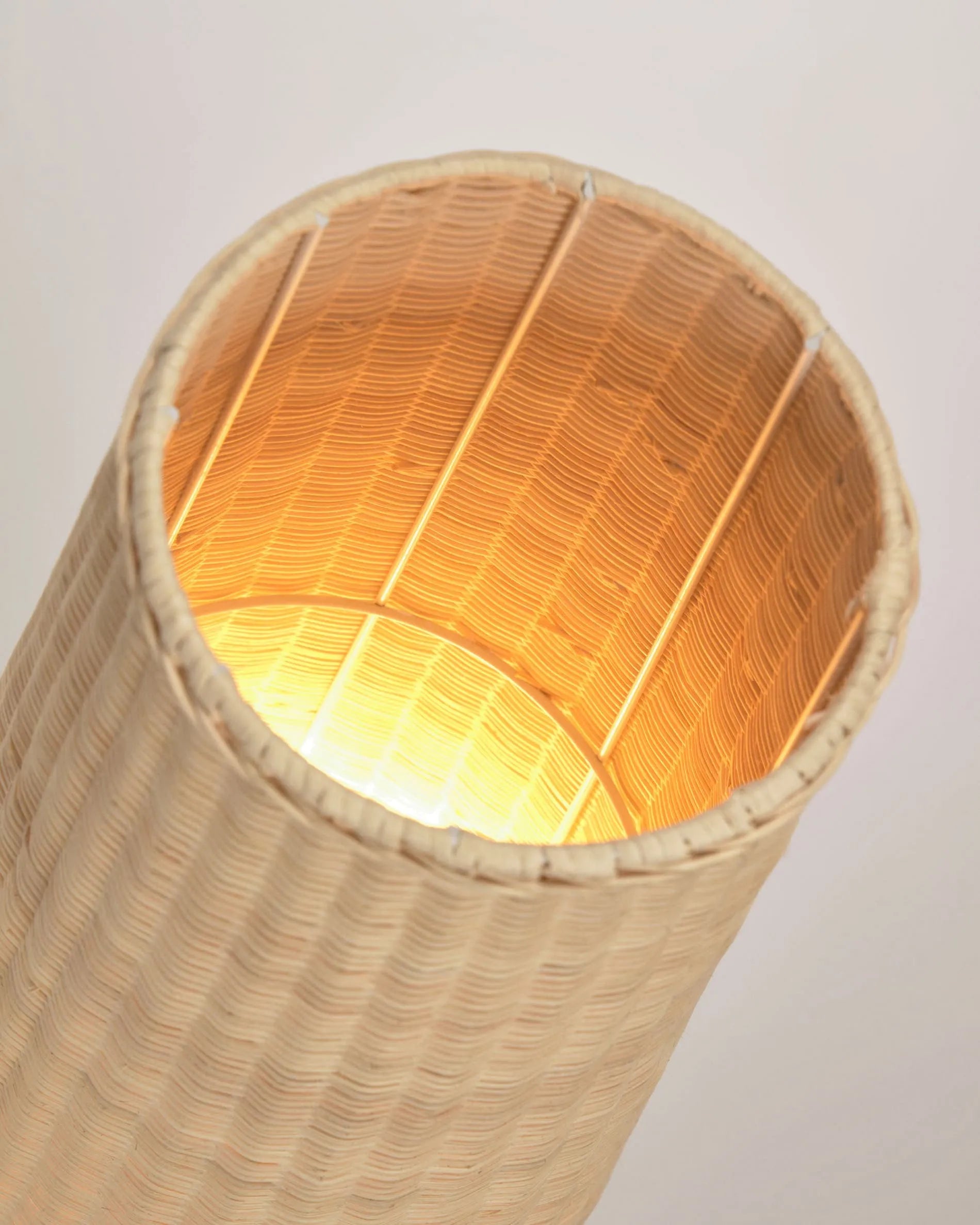 Die Kamaria Stehlampe aus handgeflochtenem Rattan bringt mit ihrem natürlichen Charme und warmem Licht eine einladende Atmosphäre in jeden Raum.