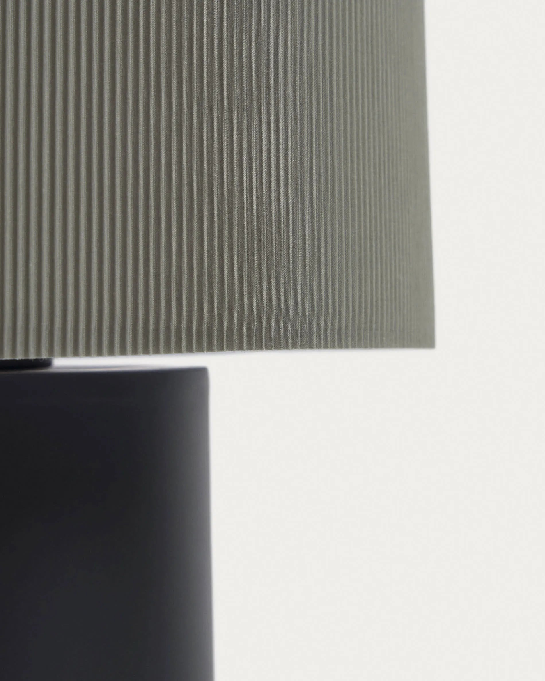 Elegante Tischlampe aus schwarzem Metall mit grauem, plissiertem Stoffschirm für stilvolle Lichtakzente.