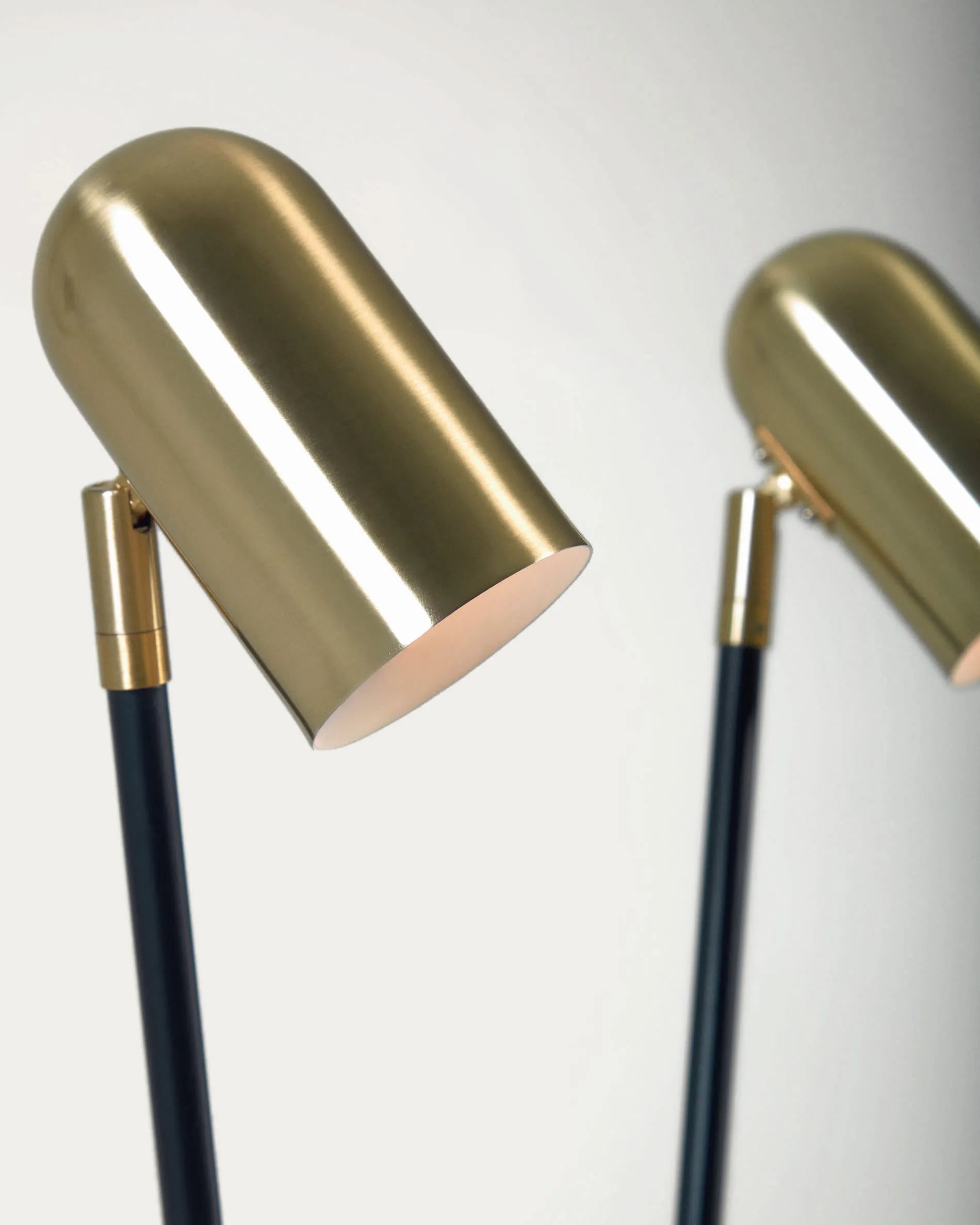 Die Clemence Stehlampe kombiniert schwarzes Metall mit goldenen Schirmen für stilvolle Eleganz und flexible Beleuchtung.