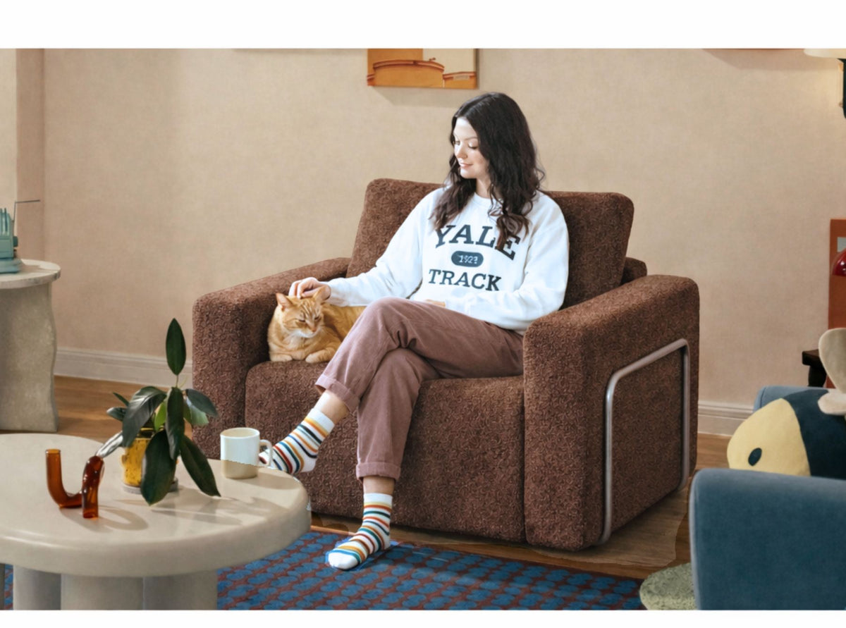 Braunes 1-Sitzer Schlafsofa aus 100% Bouclé-Stoff mit gepolsterter Sitzfläche und ausklappbarer Liegefläche in kompakter Form.