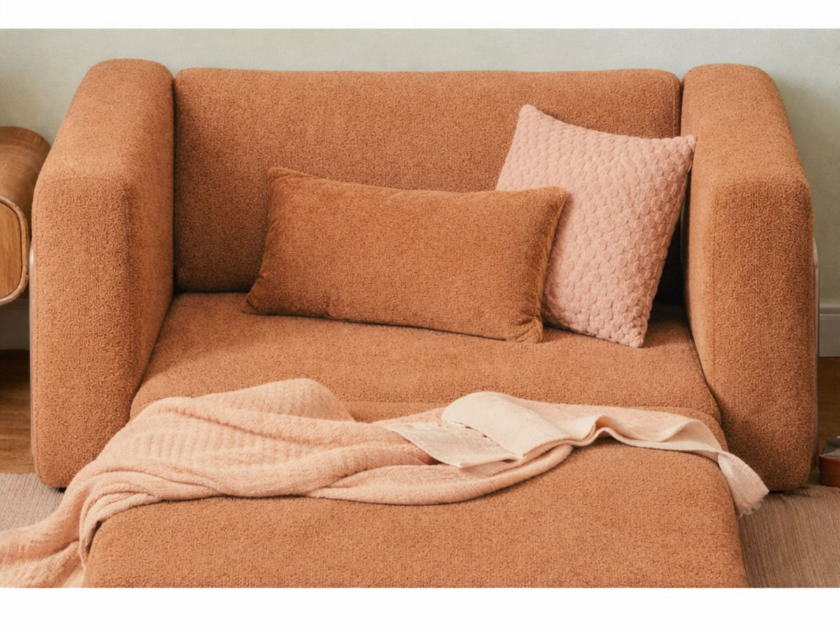 Orangefarbenes 1-Sitzer Schlafsofa aus Bouclé-Stoff mit kompakter Form, sichtbaren Füssen und leicht texturierter, flauschiger Oberfläche.