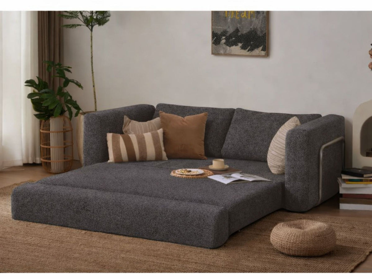 Anthrazitfarbenes 2-Sitzer Schlafsofa Wello aus Bouclé-Stoff mit kompakter Form, Armlehnen und flacher Sitzfläche, aufgestellt im Wohnraum.