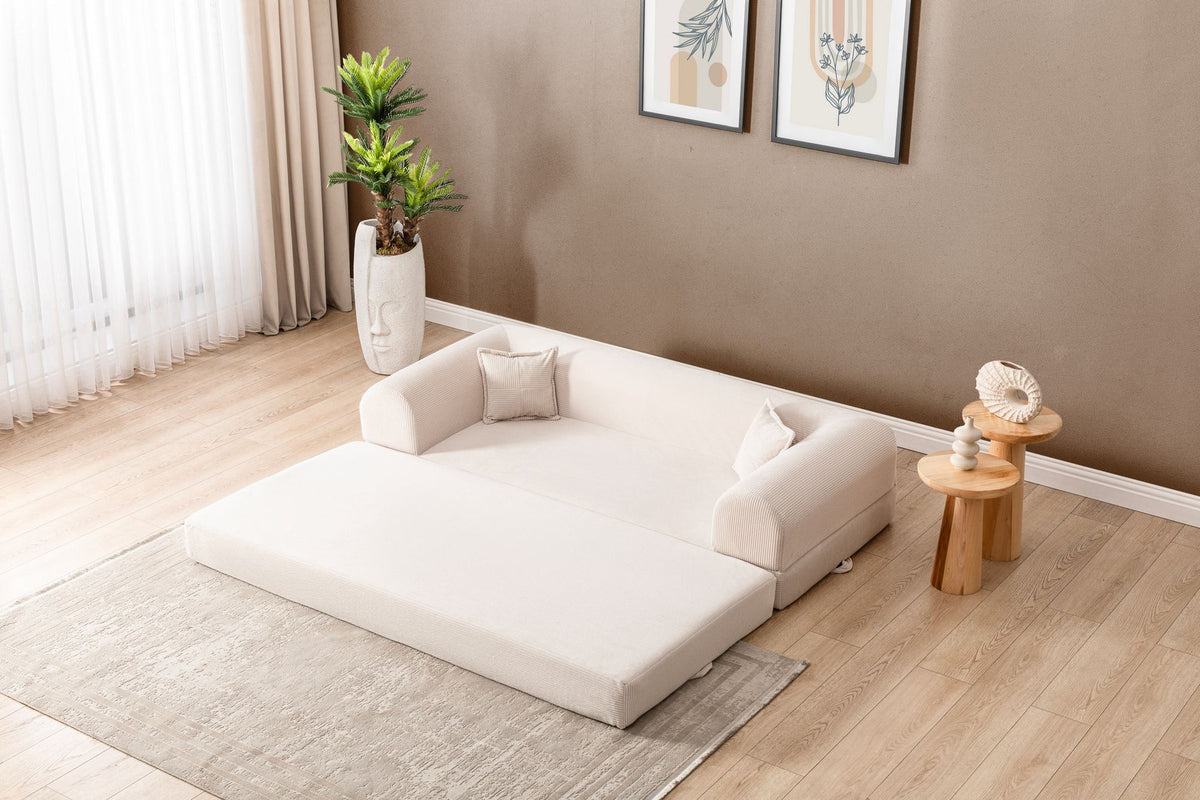 Cremefarbenes 3-Sitzer Schlafsofa Legom Eco von Hanah Home aus geripptem Cord-Plüschstoff mit zwei Kissen im Roll-Pack-Design abgebildet.