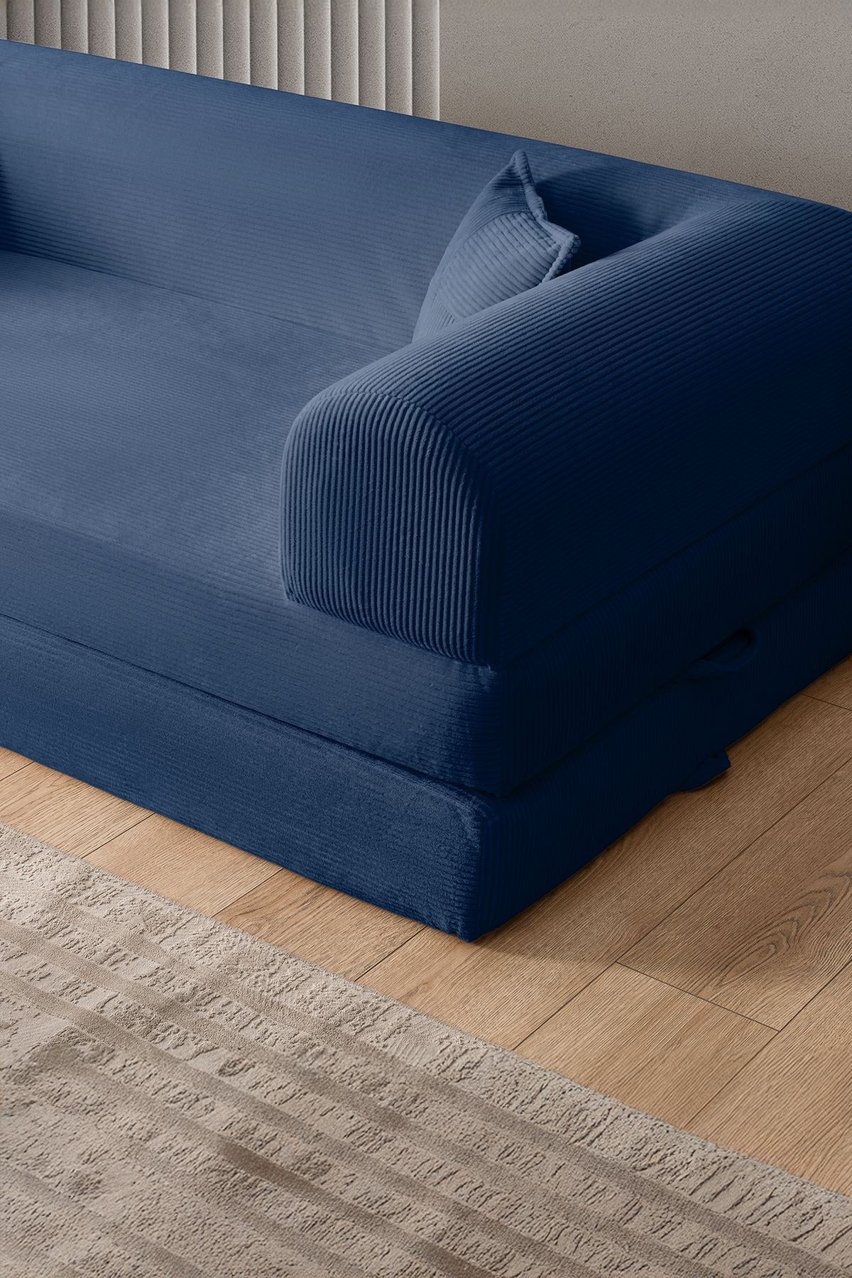 Marineblaues 3-Sitzer Schlafsofa Legom Eco von Hanah Home aus geripptem Cord-Plüschstoff mit zwei Kissen und niedrigem Rückenteil.