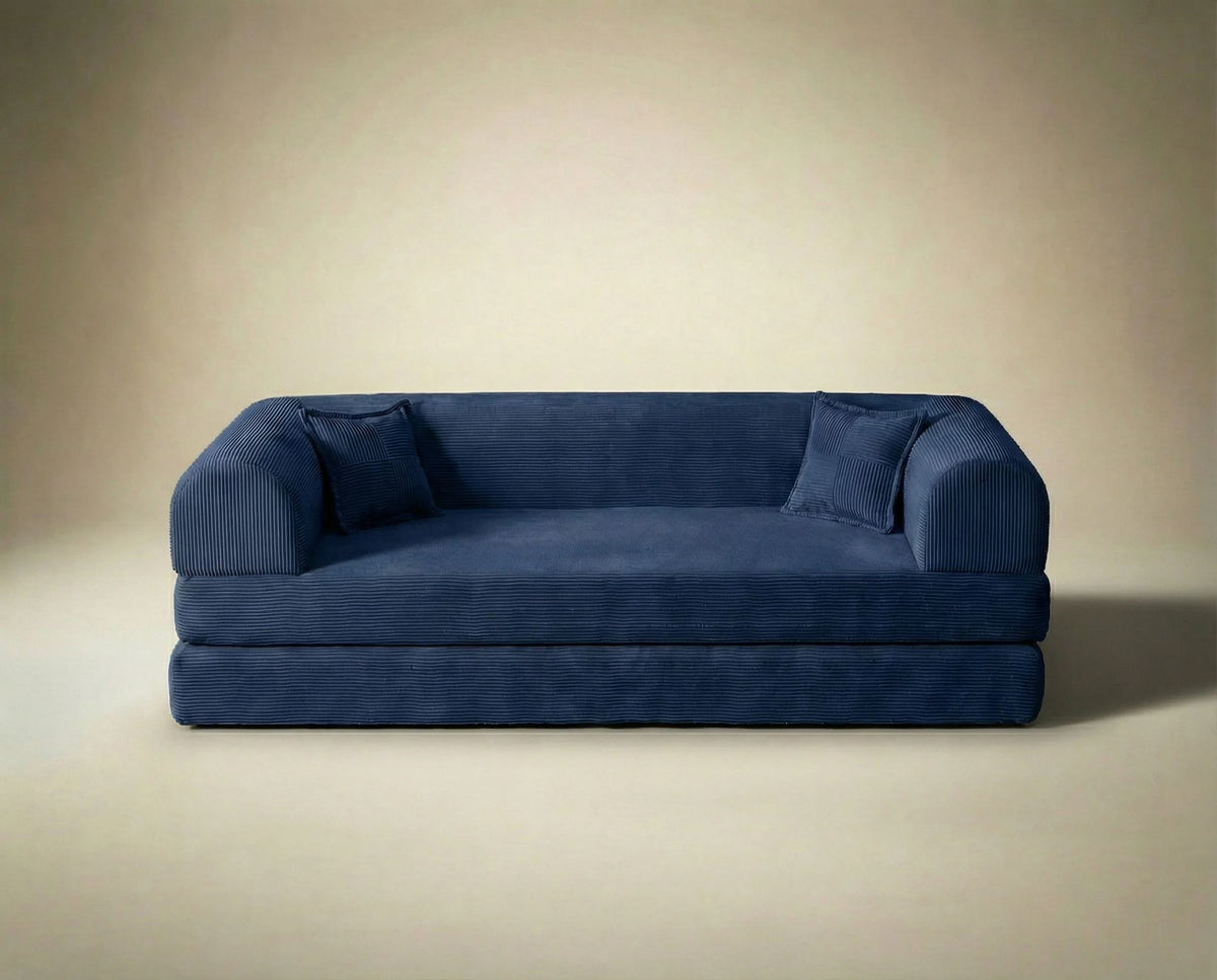 Marineblaues 3-Sitzer Schlafsofa Legom Eco von Hanah Home aus geripptem Cord-Plüschstoff mit zwei Kissen und niedrigem Rückenteil.