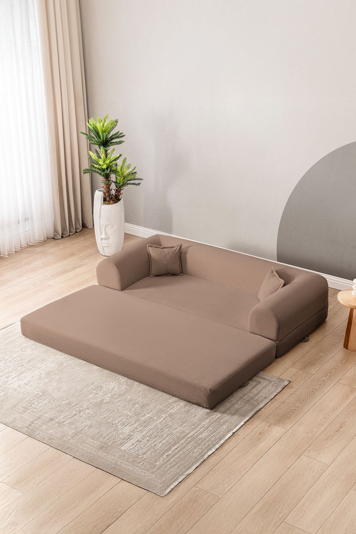 Beiges 3-Sitzer Schlafsofa aus geripptem Plüschstoff mit zwei Kissen, rutschfester Sohle und klar gerader Formgebung.