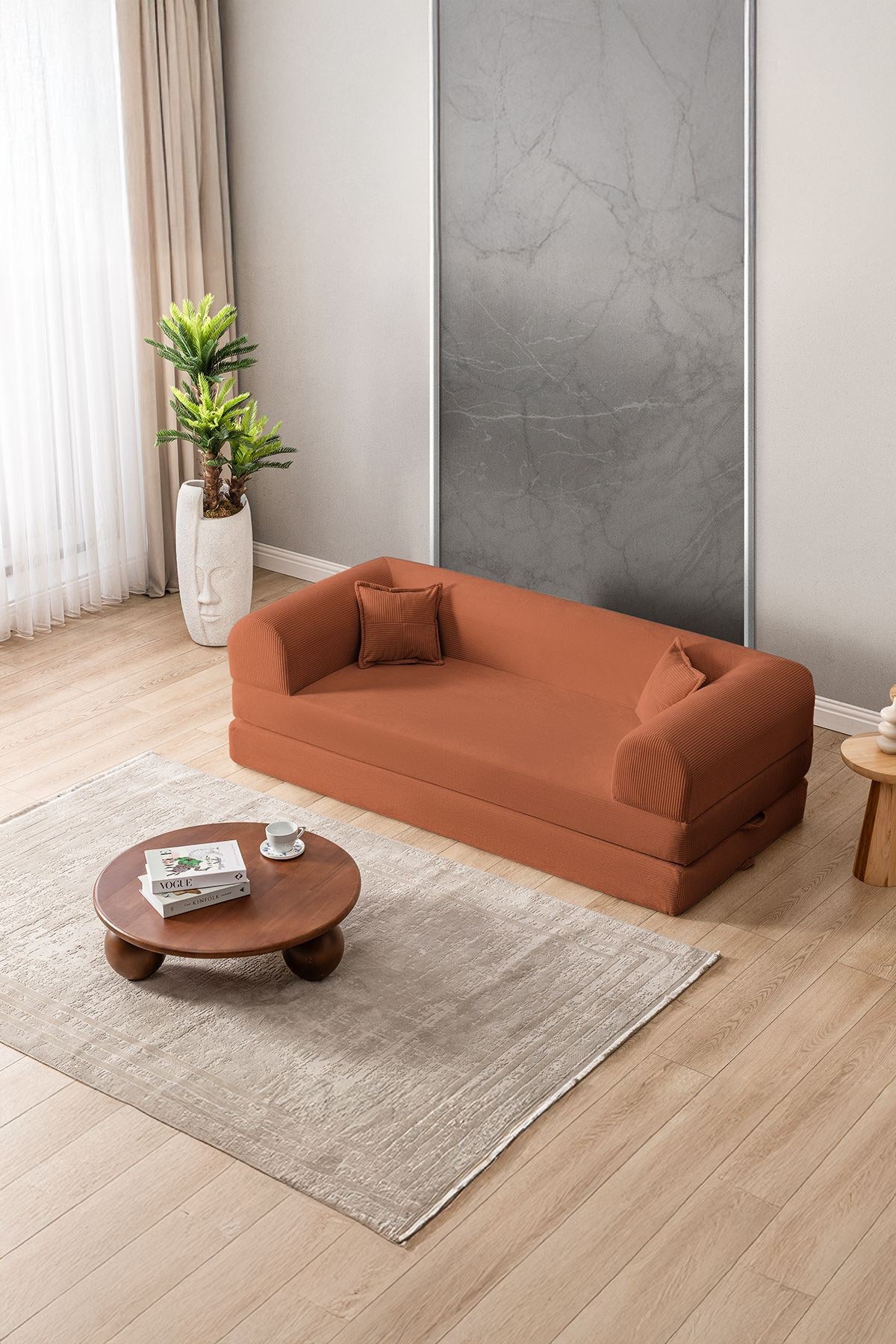 Orangefarbenes 3-Sitzer Schlafsofa aus geripptem Plüschstoff mit zwei Kissen, Rollpack-Design und rutschfester Sohle, Frontalansicht.