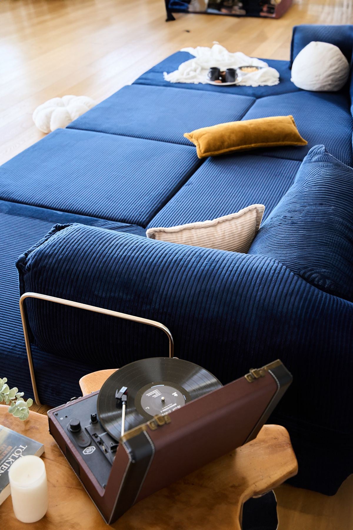 Marineblaues Eck-Schlafsofa aus Cord-Plüschstoff mit vier Kissen, Rollpack-Verpackung und abnehmbarem, waschbarem Bezug.
