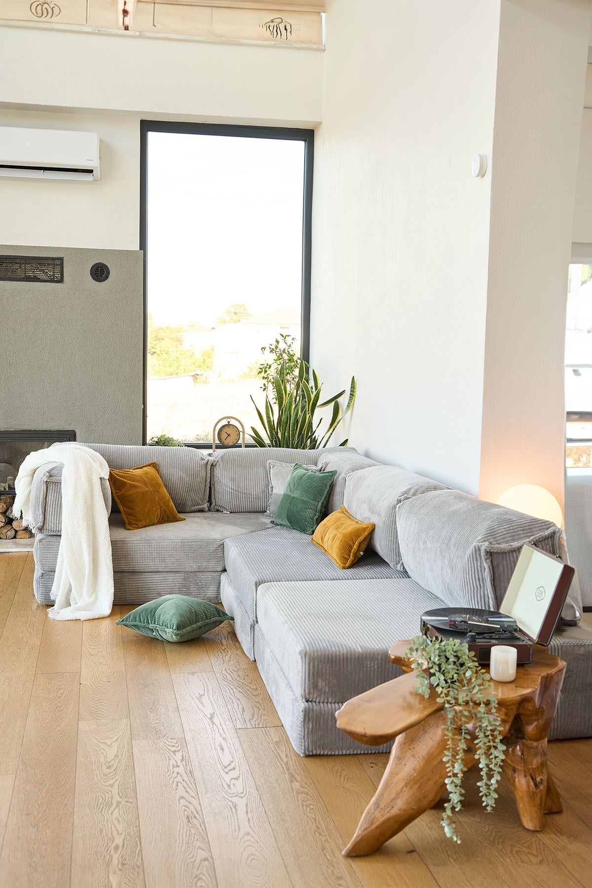 Hellgraues Eck-Schlafsofa Kanyon von Hanah Home aus Cord-Plüschstoff mit vier Kissen, Ecksofa-Form, Sitzhöhe 36 cm.