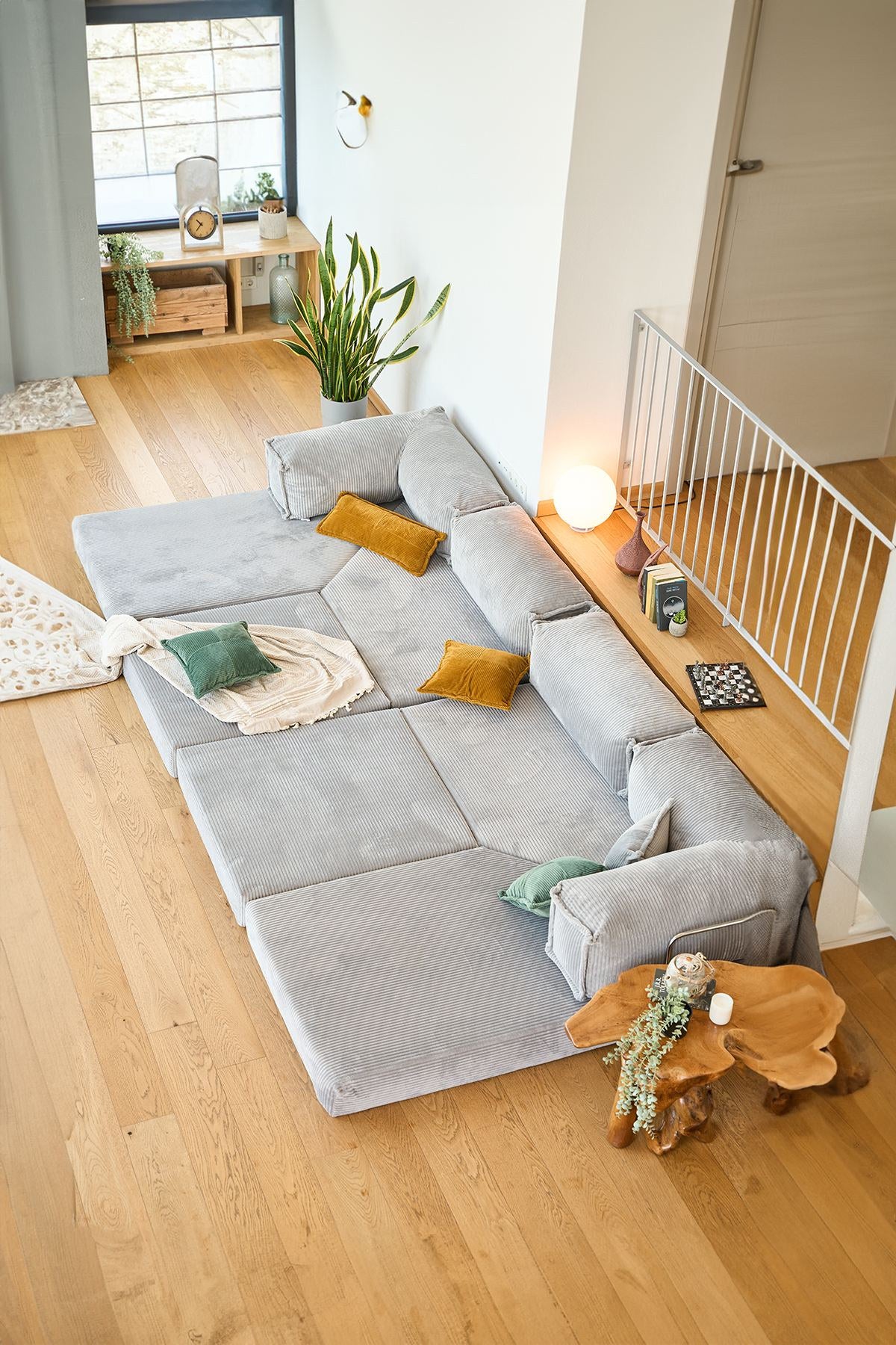 Hellgraues Eck-Schlafsofa Kanyon von Hanah Home aus Cord-Plüschstoff mit vier Kissen, Ecksofa-Form, Sitzhöhe 36 cm.