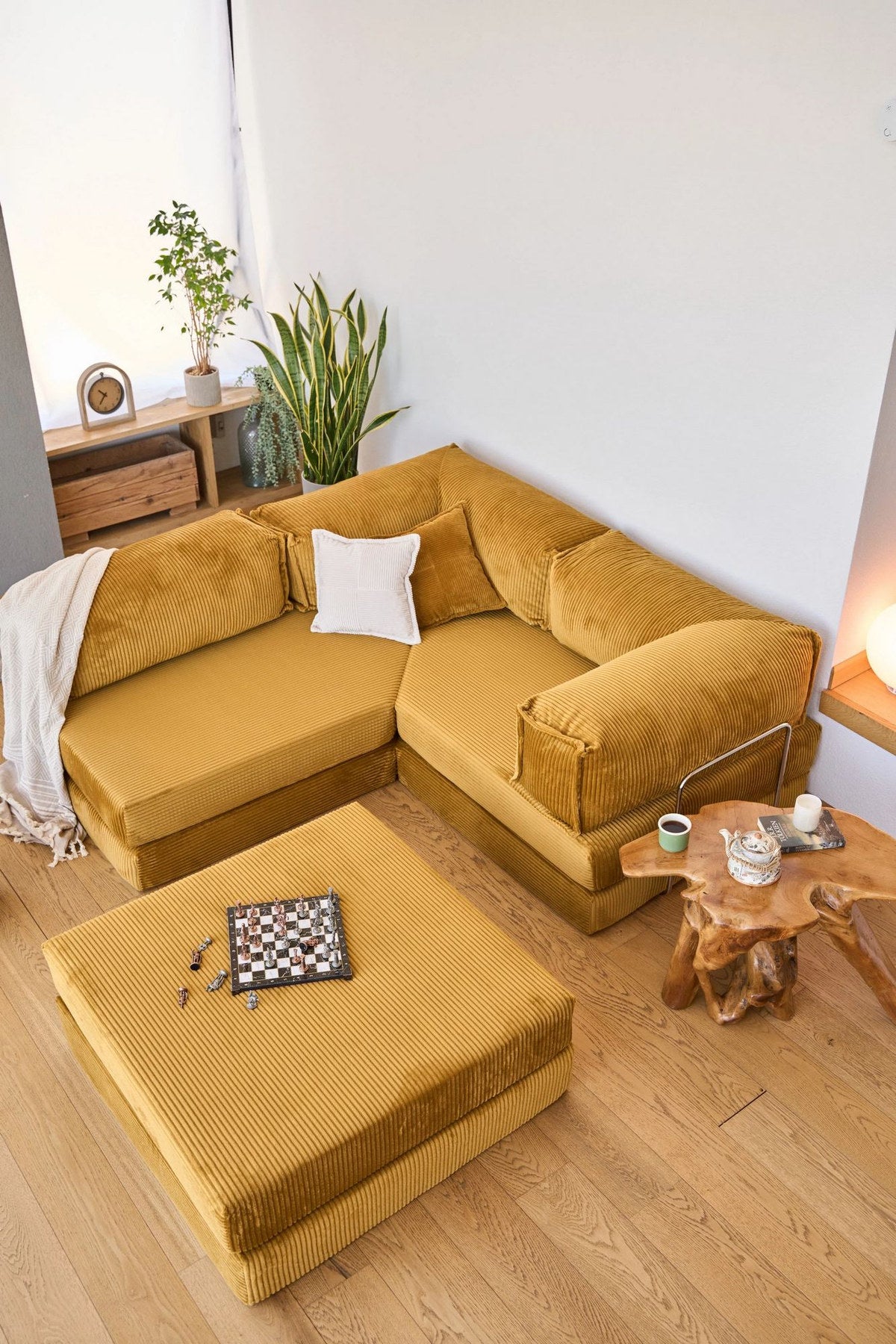 Senfgelbes Eck-Schlafsofa Kanyon von Hanah Home aus geripptem Cord-Plüschstoff mit vier Kissen und rutschfester Sohle.