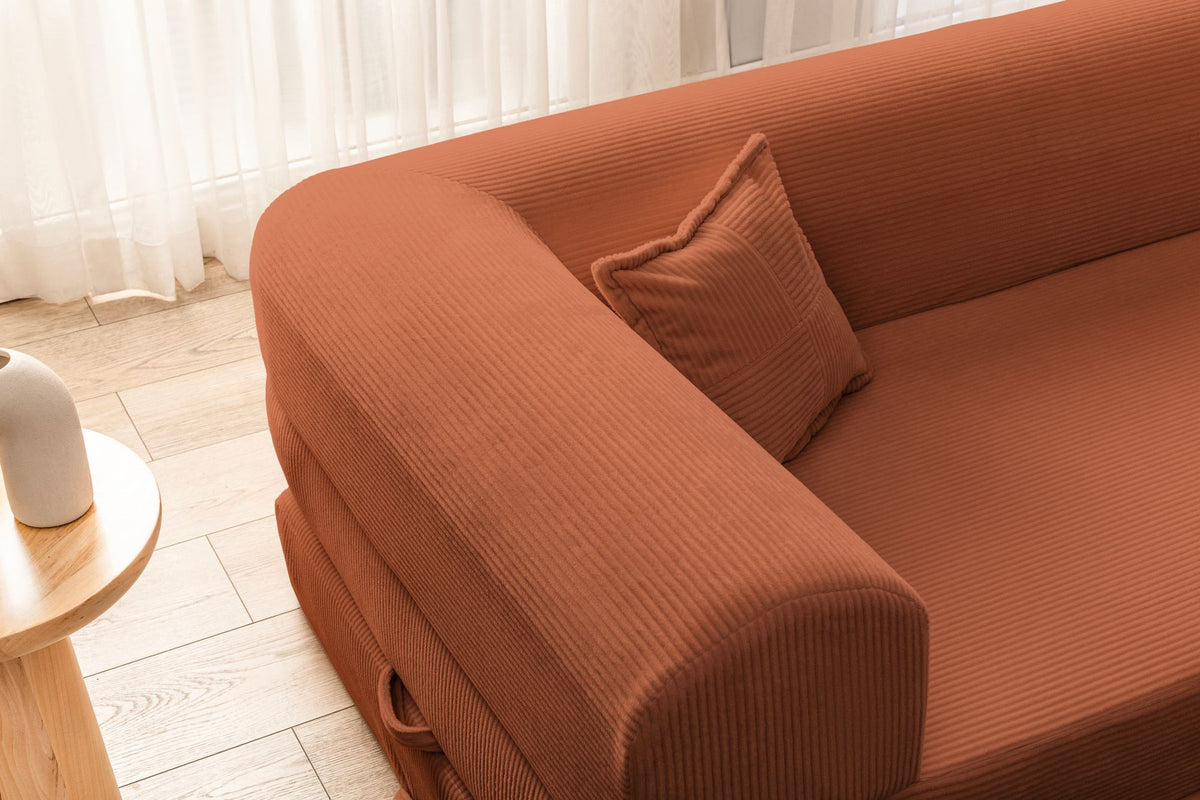 Ecksofa-Bett in Ziegelrot mit Cord-Plüschstoff-Bezug, vier Kissen, Rollpack-Design, Sitzhöhe 36 cm, Rückenhöhe 25 cm, Masse 280x90 cm.
