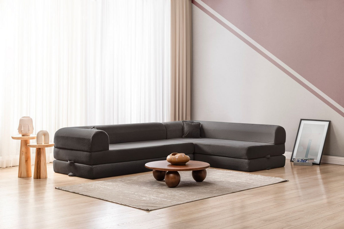 Anthrazitfarbenes Ecksofa-Bett aus geripptem Plüschstoff mit vier Kissen, Rollpack-Design und abnehmbarem Bezug, Hanah Home.