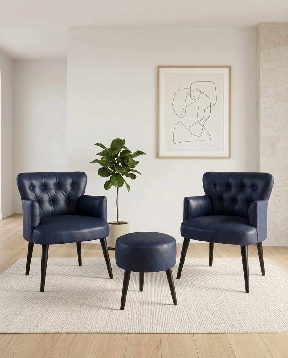 Zwei dunkelblaue Ohrensessel und passender Hocker aus PU-Leder mit Hainbuche-Beinen, Set von Hanah Home vor neutralem Hintergrund fotografiert.