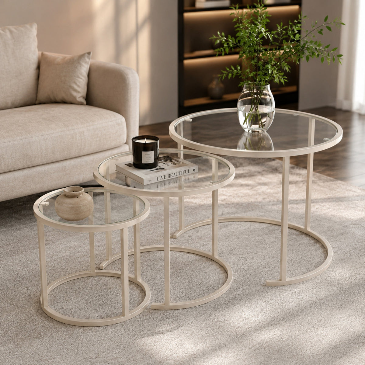 Dreiteiliges Couchtisch-Set von Hanah Home in Beige aus gehärtetem Glas mit schlankem Metallgestell, drei Tische in unterschiedlichen Grössen.