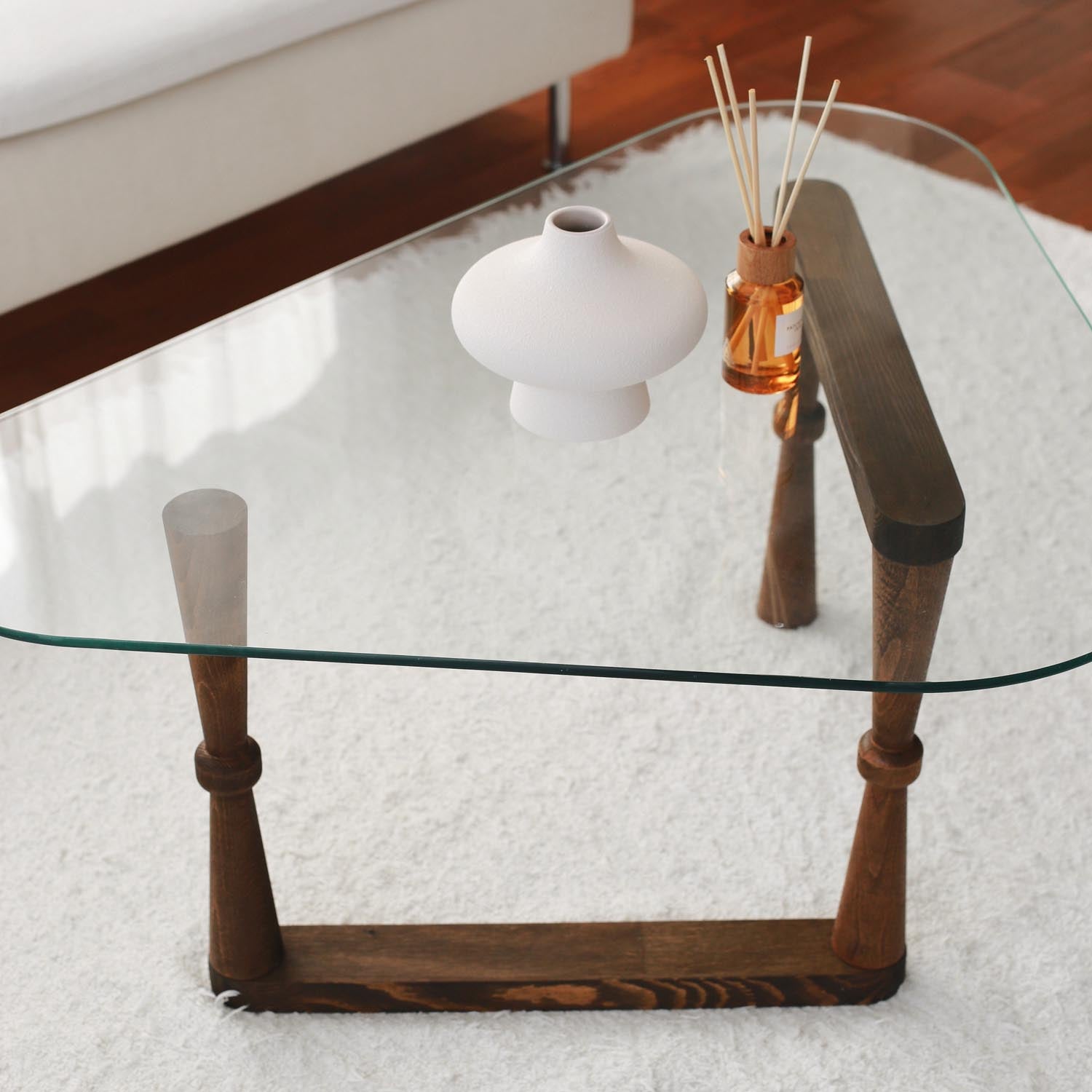Erleben Sie den Cam Orta Sehpa Sofatisch in edlem Walnuss-Finish. Robustes Buchenholz und elegantes Glas schaffen ein harmonisches Wohnambiente.