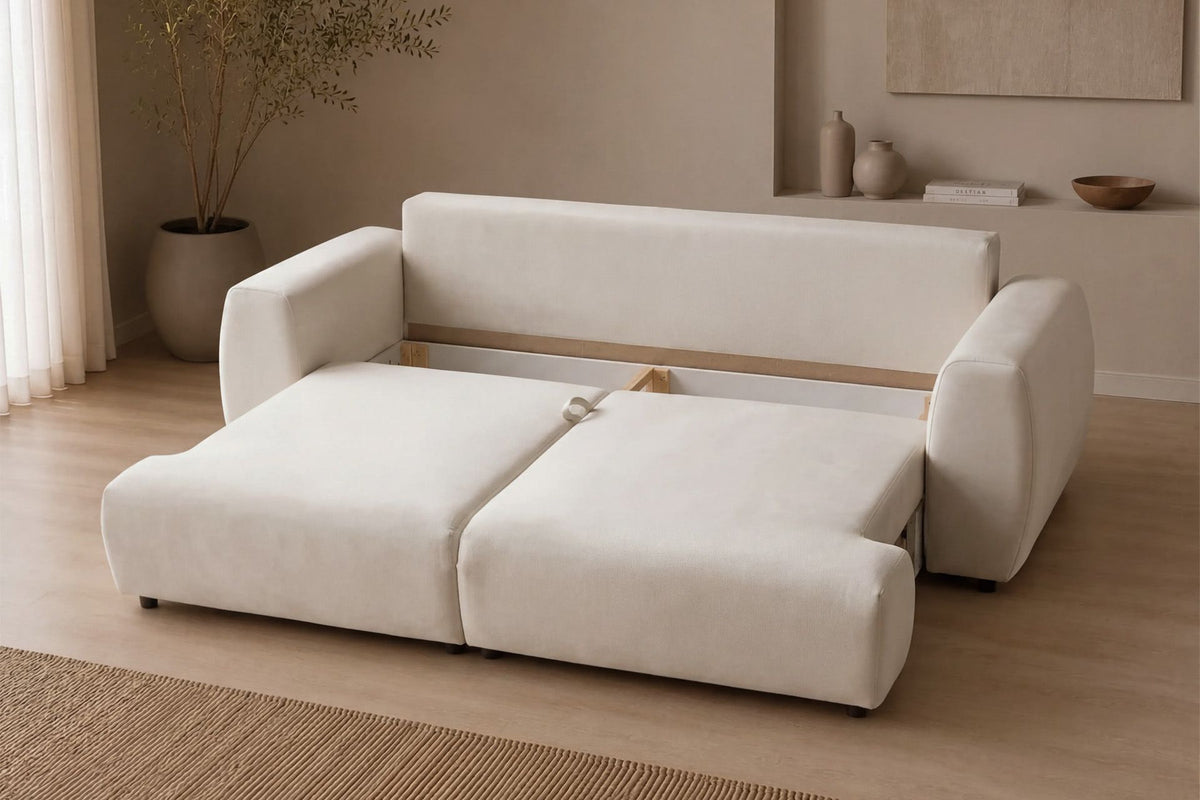 Cremefarbenes 3-Sitzer Schlafsofa Arthur aus Polyesterstoff mit Buchenholzgestell, Kunststoffbeinen und verstellbarer Rückenlehne, zwei Kissen inklusive.