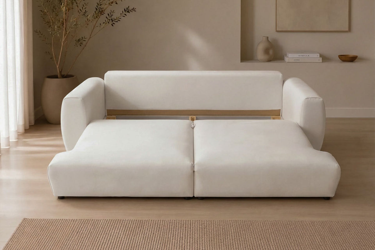 Cremefarbenes 3-Sitzer Schlafsofa Arthur aus Polyesterstoff mit Buchenholzgestell, Kunststoffbeinen und verstellbarer Rückenlehne, zwei Kissen inklusive.