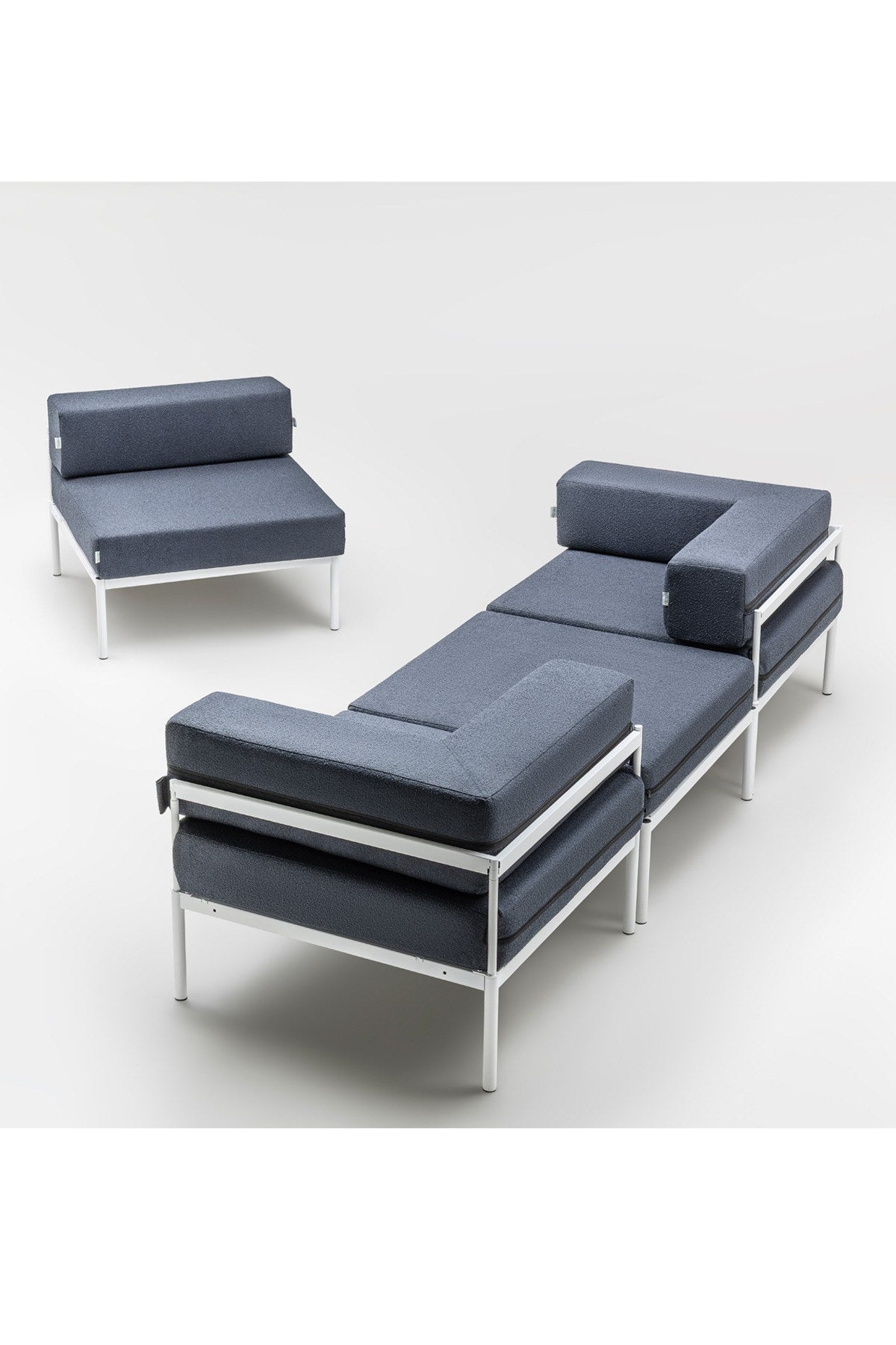 Weisses Ecksofa mit marineblauen Elementen, Bouclé-Stoff, Metallbeine, breite Sitzfläche und verstellbare Rückenlehne im Wohnzimmer.