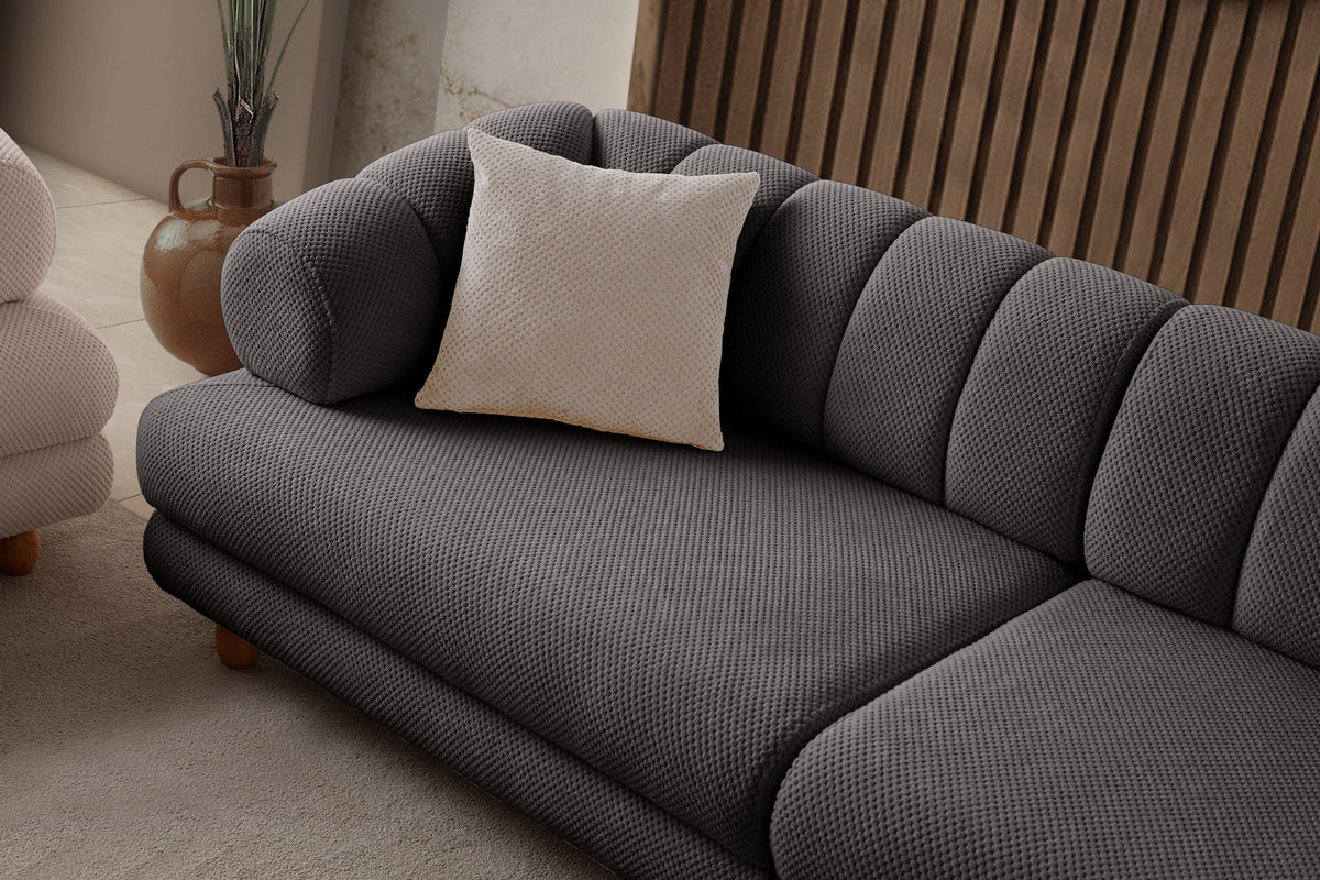 Anthrazitfarbenes 3-Sitzer Sofa mit Polyesterbezug in Tuna-Struktur, Holzbeinen und zwei losen Kissen auf hellem Untergrund.