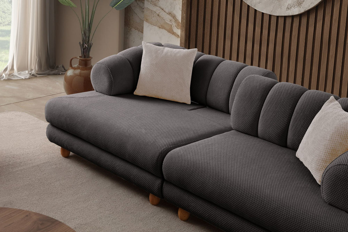 Anthrazitfarbenes 3-Sitzer Sofa mit Polyesterbezug in Tuna-Struktur, Holzbeinen und zwei losen Kissen auf hellem Untergrund.