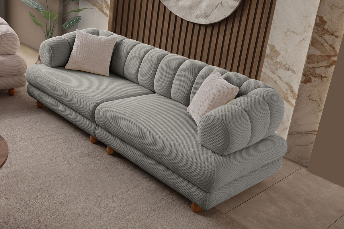 Graues 3-Sitzer Sofa Gloria von Hanah Home mit Polyesterbezug in Tuna-Struktur, Holzbeinen und zwei losen Kissen auf hellem Untergrund.