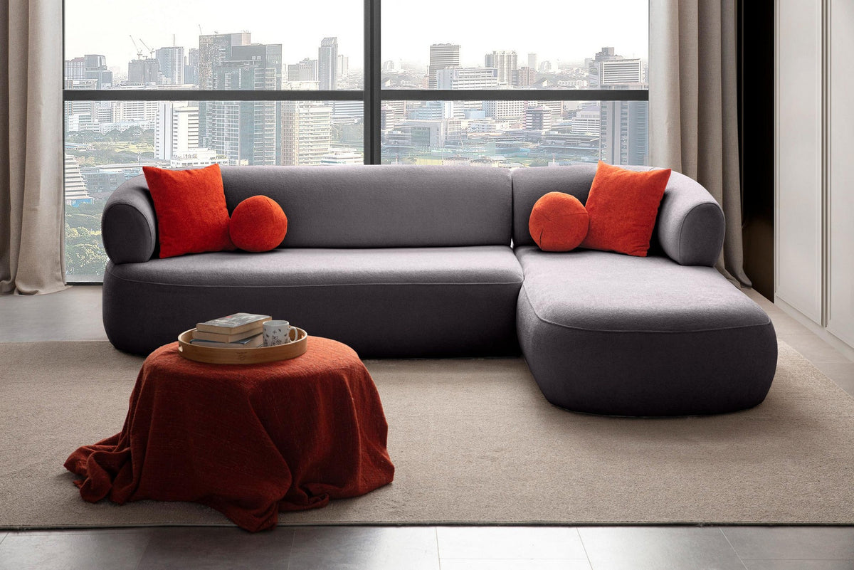 Dunkelgraues Roma Ecksofa rechts von Hanah Home mit Boucle-Stoff, Kunststoffbeinen und vier passenden Kissen im Wohnzimmer.