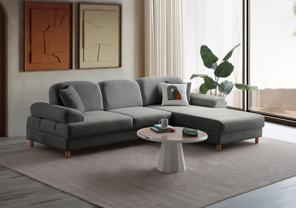 Anthrazitfarbenes Eck-Schlafsofa Aries von Hanah Home mit Coco-Boucle-Bezug, Holzbeinen und ausklappbarer Liegefläche in Wohnraumumgebung.