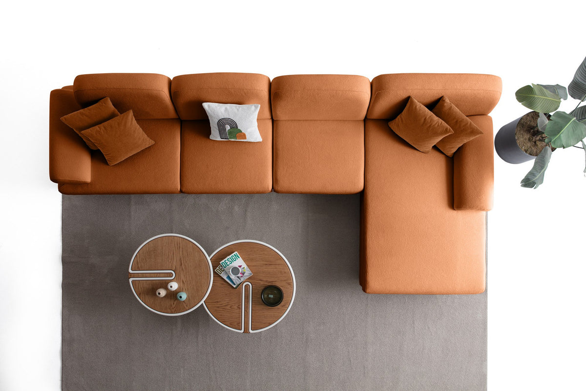 Eck-Schlafsofa Aries Relax Joker in Orange mit Coco-Boucle-Stoff, Holzbeinen und ausklappbarer Liegefläche, fotografiert im Wohnraum.